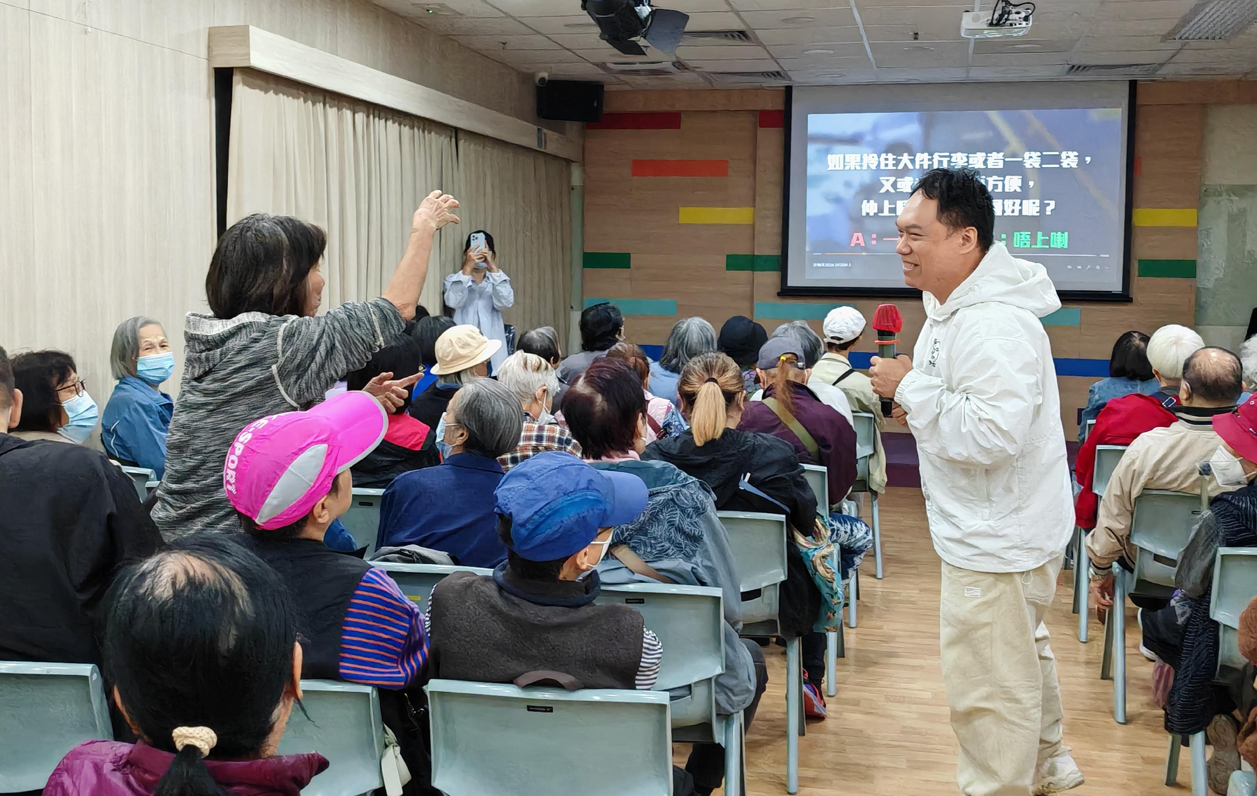 The Transport Department (TD) has held interactive sharing sessions and game activities at primary schools and District Elderly Community Centres in various districts since late 2024, aiming to raise the awareness of students and the elderly on bus and pedestrian safety. Photo shows a visit to a District Elderly Community Centre by the TD to promote bus safety.