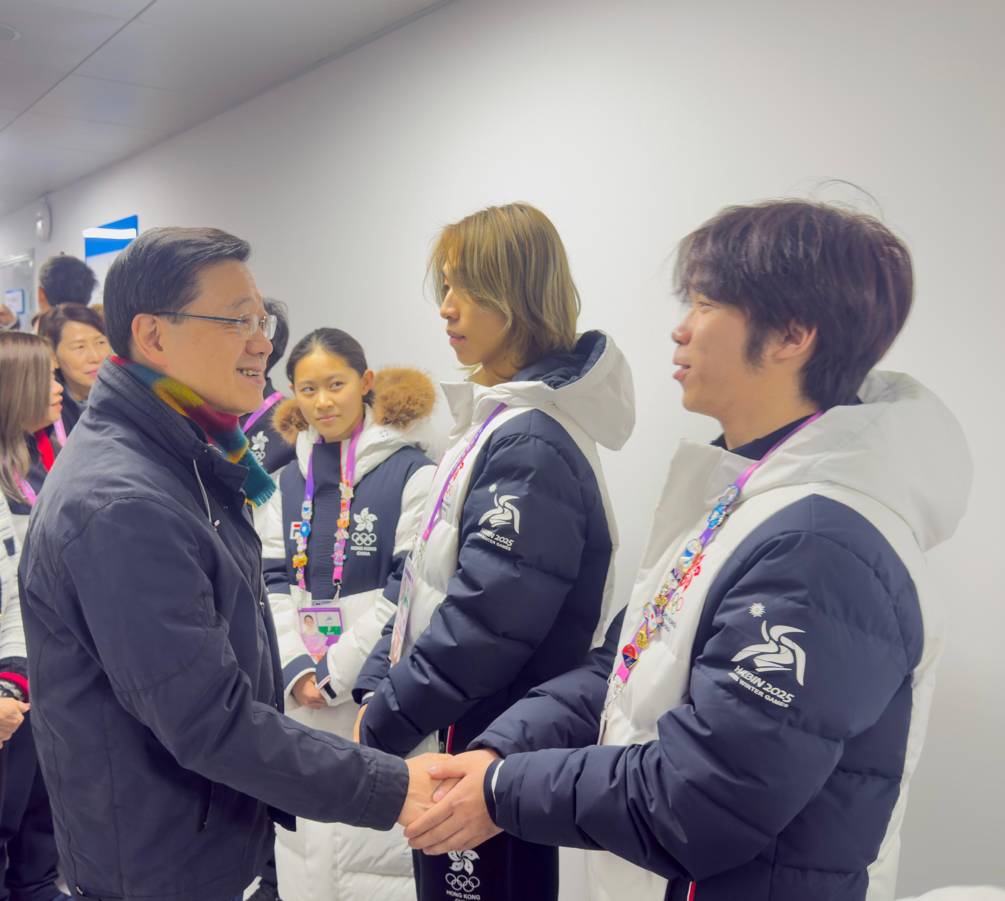 The Chief Executive, Mr John Lee, continued his visit programme in Harbin today (February 8). Photo shows Mr Lee (left) interacting with Hong Kong athletes after watching a competition at the 9th Asian Winter Games Harbin 2025.