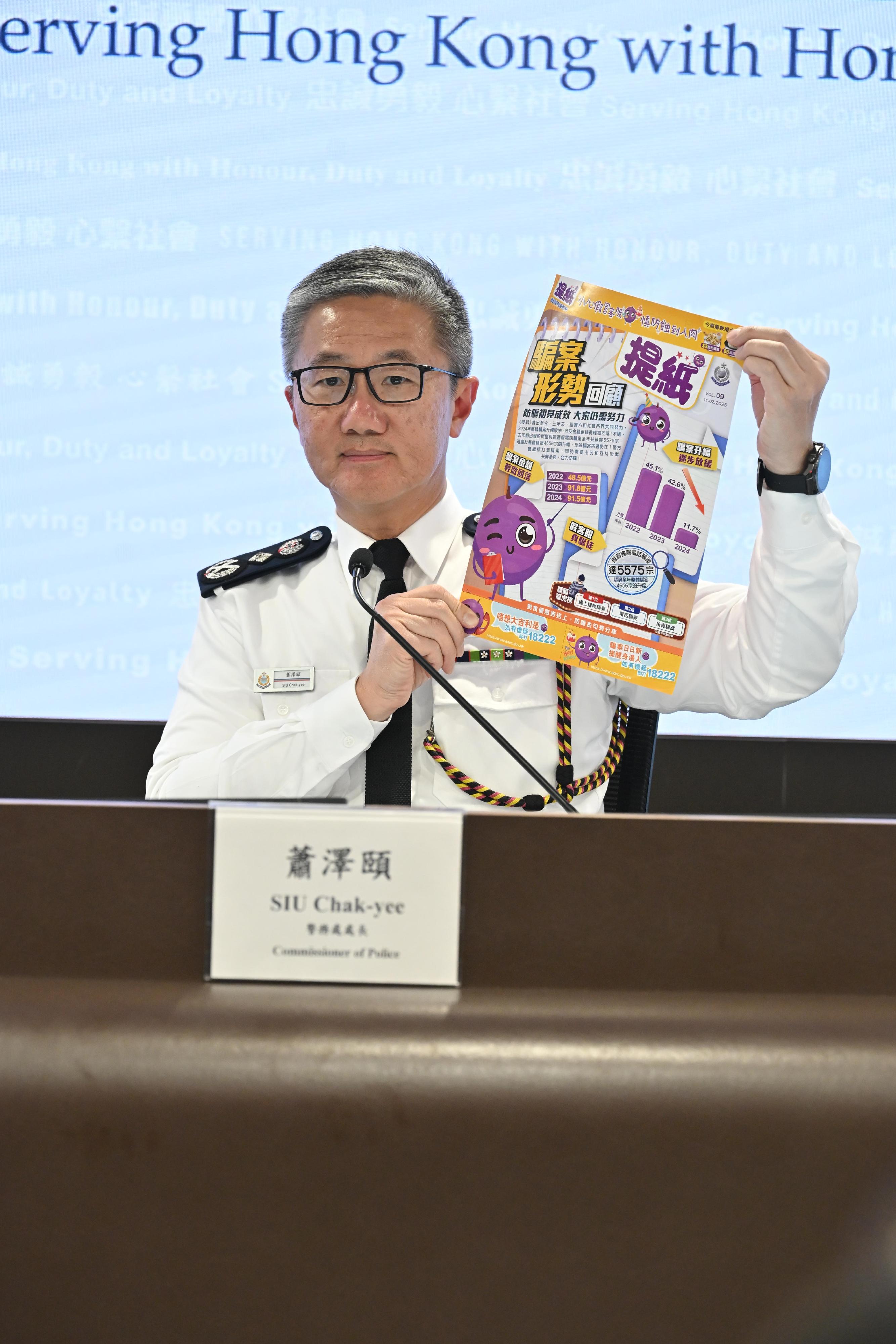 警務處處長蕭澤頤今日（二月十一日）在記者會上回顧2024年香港的治安情況及警務工作。圖示蕭澤頤展示警方透過中英文各一份免費報紙向市民派發的防騙宣傳品《提紙》。