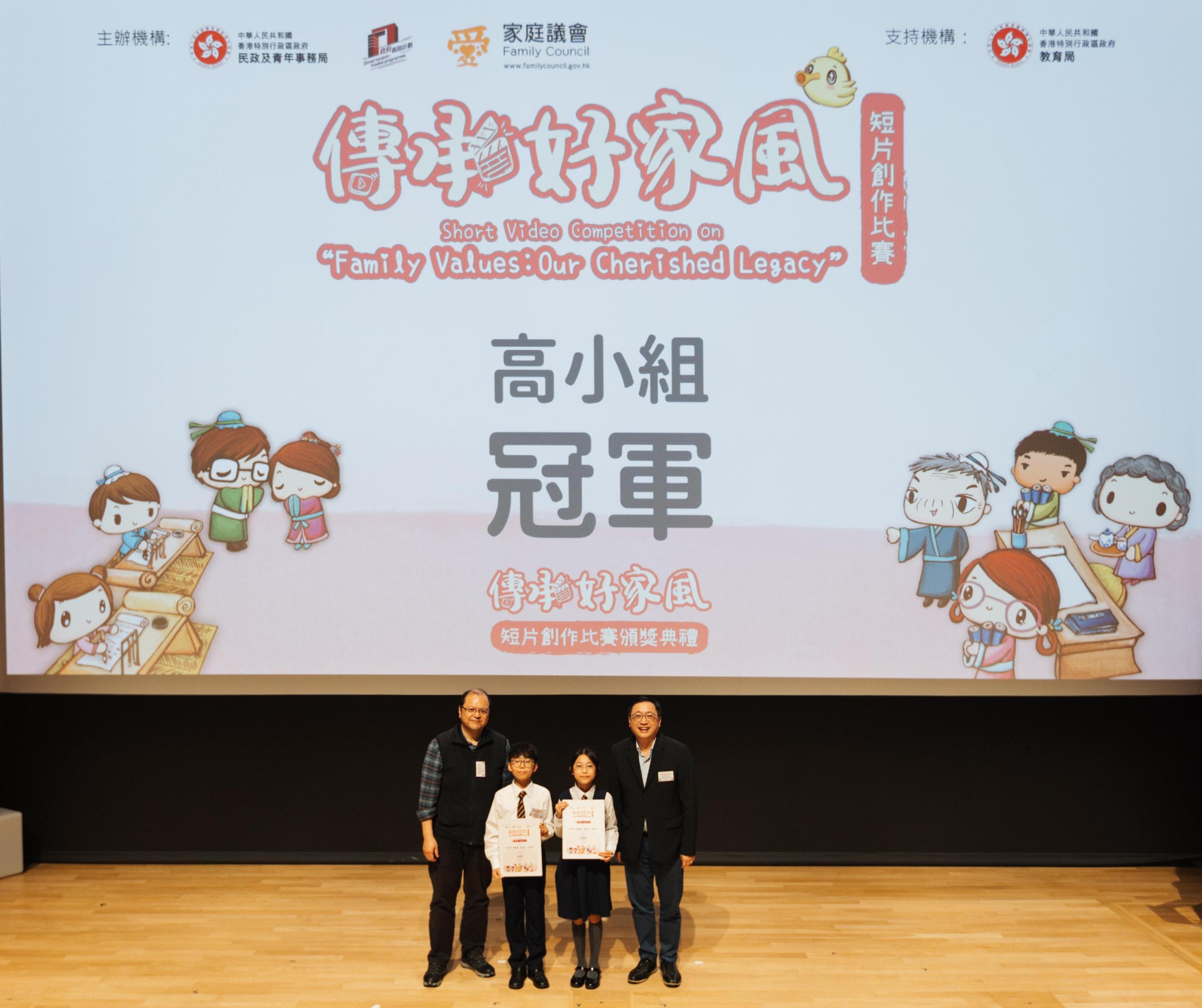 The Home and Youth Affairs Bureau and the Family Council held the award presentation ceremony of the Short Video Competition on "Family Values: Our Cherished Legacy" today (February 16). Photo shows the Convenor and Deputy Convenor of the Sub-committee on the Promotion of Family Core Values and Family Education of the Family Council, Mr Eugene Fong (first right) and Mr Felix Law (first left), posing for a photo with the champion of senior primary school students category.