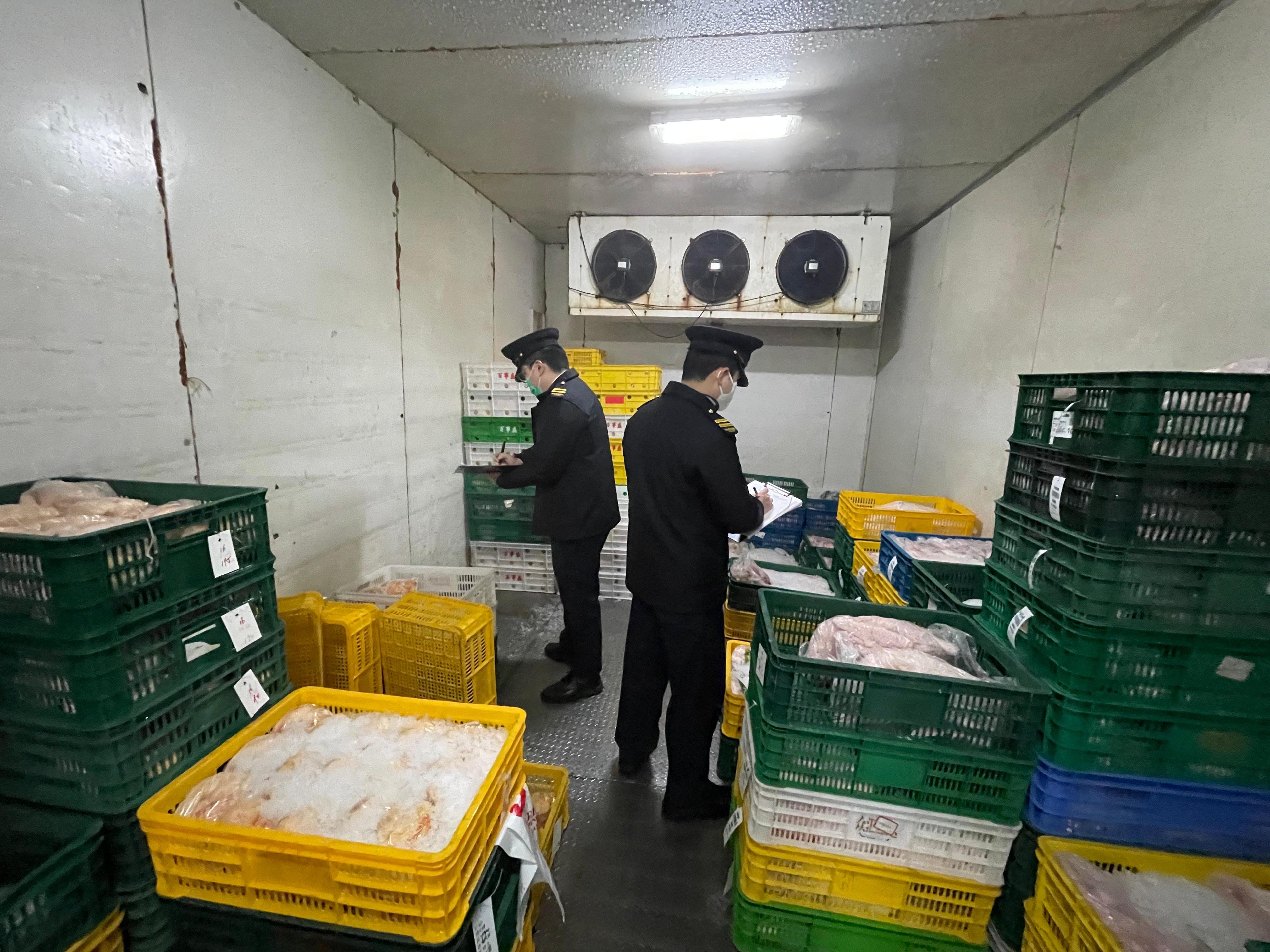 The Food and Environmental Hygiene Department (FEHD) raided an unlicensed cold store last night (February 18) at Tai Shu Ha Road West, Yuen Long. Photo shows FEHD officers checking the store's stock.