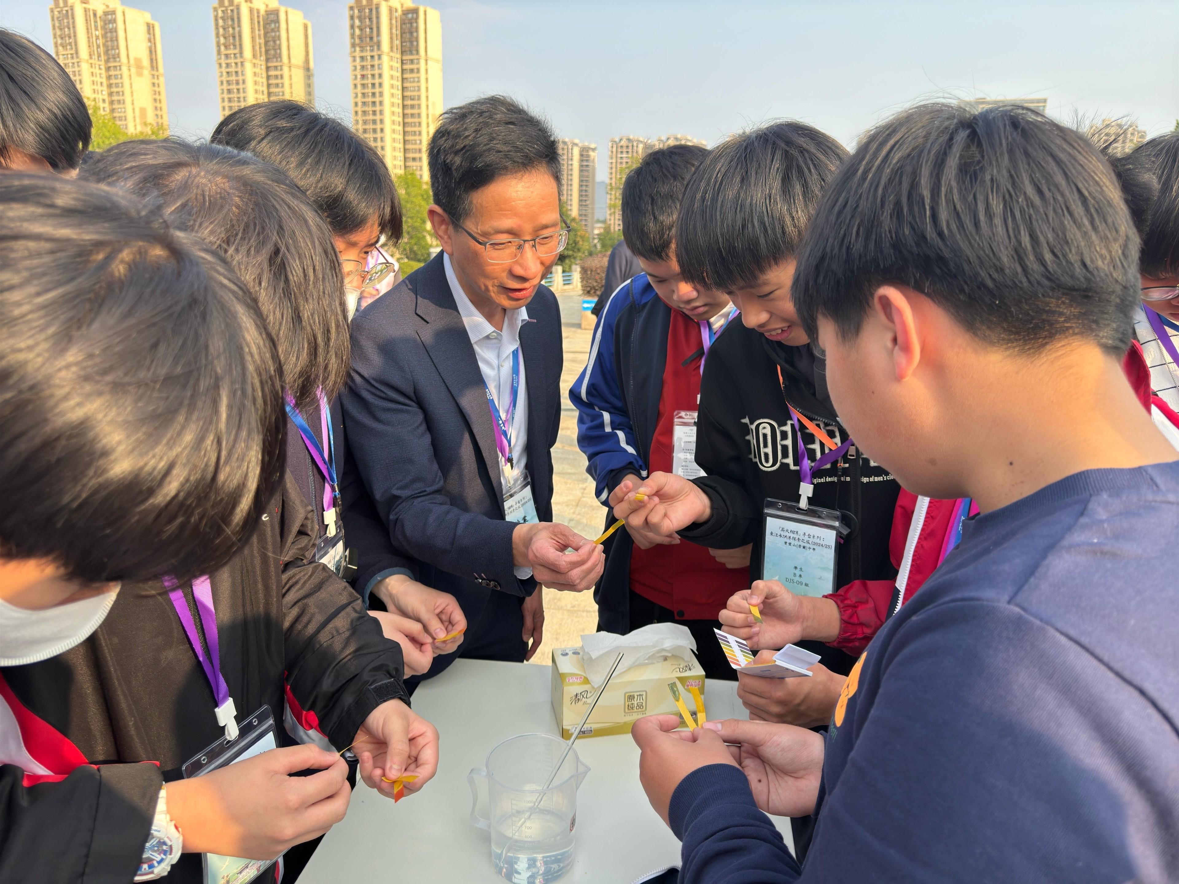 The Development Bureau, the Education Bureau and the Water Supplies Department (WSD) jointly organised the Mainland study tour "An Exploration into the Supply of Dongjiang Water to Hong Kong" for secondary students on February 20 and 21. About 90 vice-principals, teachers and students from secondary schools visited facilities related to the Dongjiang-Shenzhen Water Supply Scheme in Guangdong Province. Photo shows a representative of the WSD teaching students how to conduct simple water quality tests to learn about the standard of Dongjiang water supplied to Hong Kong.