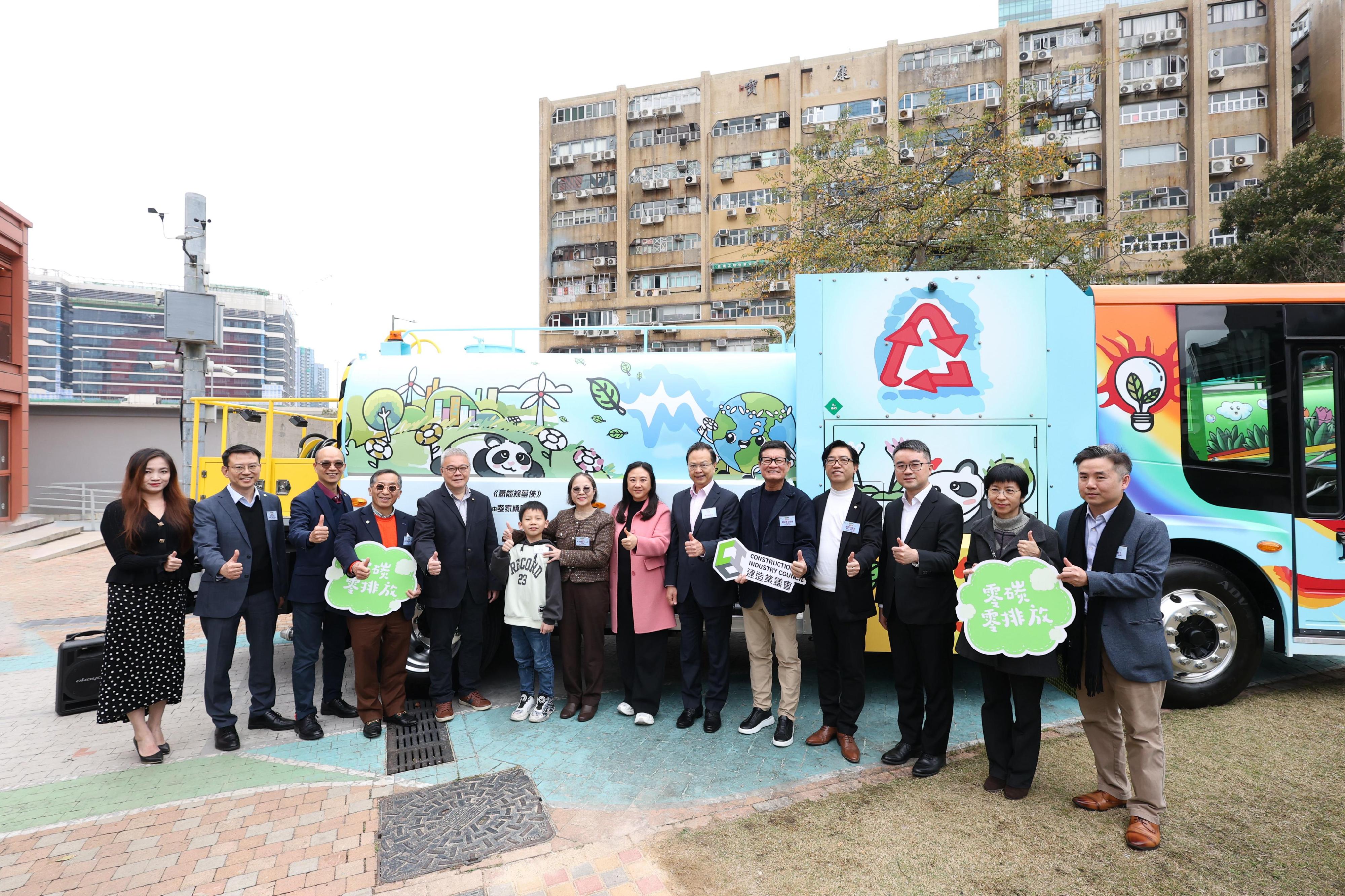 The Hydrogen Zero Carbon STEAM Carnival, organised by the Electrical and Mechanical Services Department and co-organised by the Education Bureau and the Construction Industry Council - Zero Carbon Park, is being held today and tomorrow (February 22 and 23). Photo shows the guests and a winning student of the Hydrogen Fuelled Street Washing Vehicle Naming and Drawing Contest in front of a hydrogen-fuelled street washing vehicle in its new livery.

