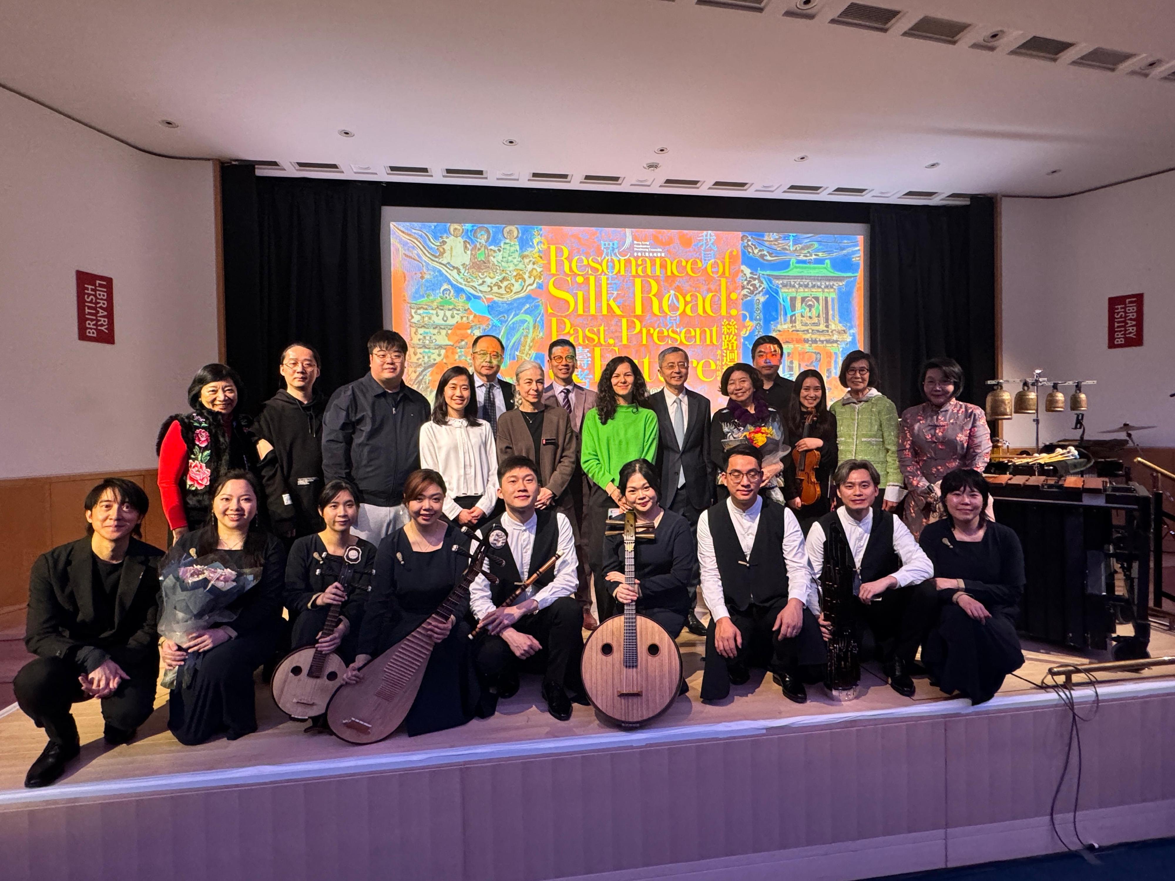 The Hong Kong Economic and Trade Office, London (London ETO) supported the Hong Kong Gaudeamus Dunhuang Ensemble's concert, titled "Resonance of the Silk Road: Past, Present & Future Concert", at the British Library in London, the United Kingdom (UK), on February 21 (London time). Photo shows Minister of the Embassy of the People's Republic of China in the UK, Mr Wang Qi (back row, sixth right); the Director-General of the London ETO, Mr Gilford Law (back row, seventh left); the founder of the ensemble, Ms Leonie Ki (back row, fifth right); the Head of the Asian and African Collections Department of the British Library, Dr Luisa Mengoni (back row, sixth left), and other guests with the members of the ensemble after the concert.  
