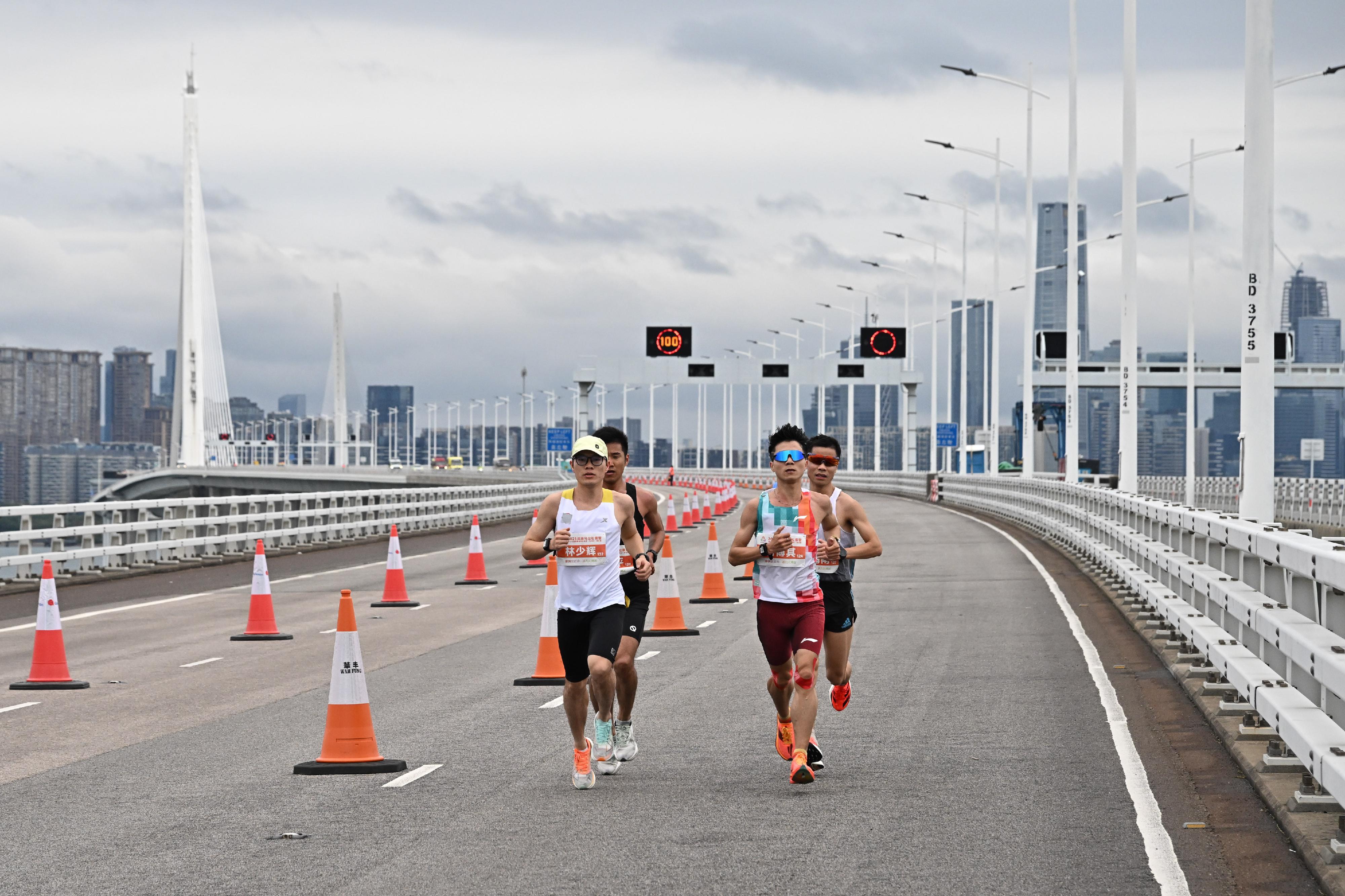 The 2025 Shenzhen-Hong Kong marathon and the 15th National Games athletics (marathon) test event was held today (February 23). Photo shows runners of the men's race running along the Kong Sham Western Highway Viaduct.
