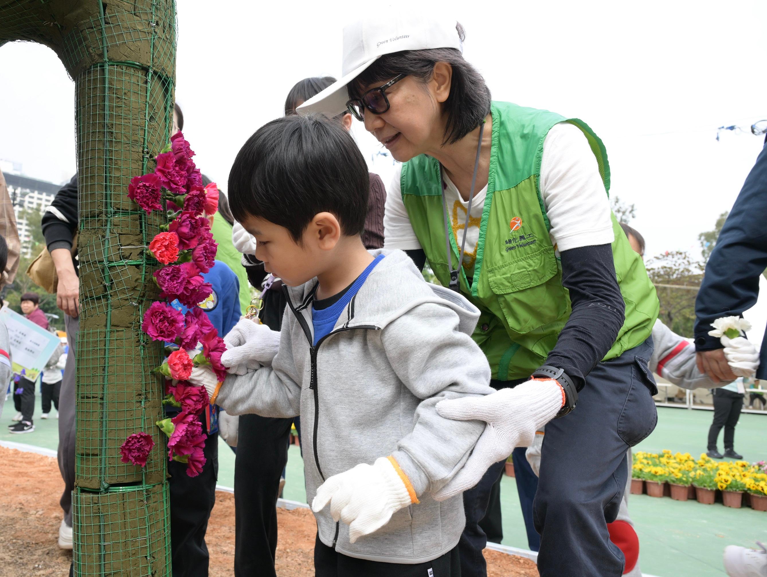 More than 1 100 students from 38 schools helped put on a spectacular horticultural display, "Wonders of Africa", at Victoria Park today (March 1). Photo shows a student working on the display under the guidance of a green volunteer.