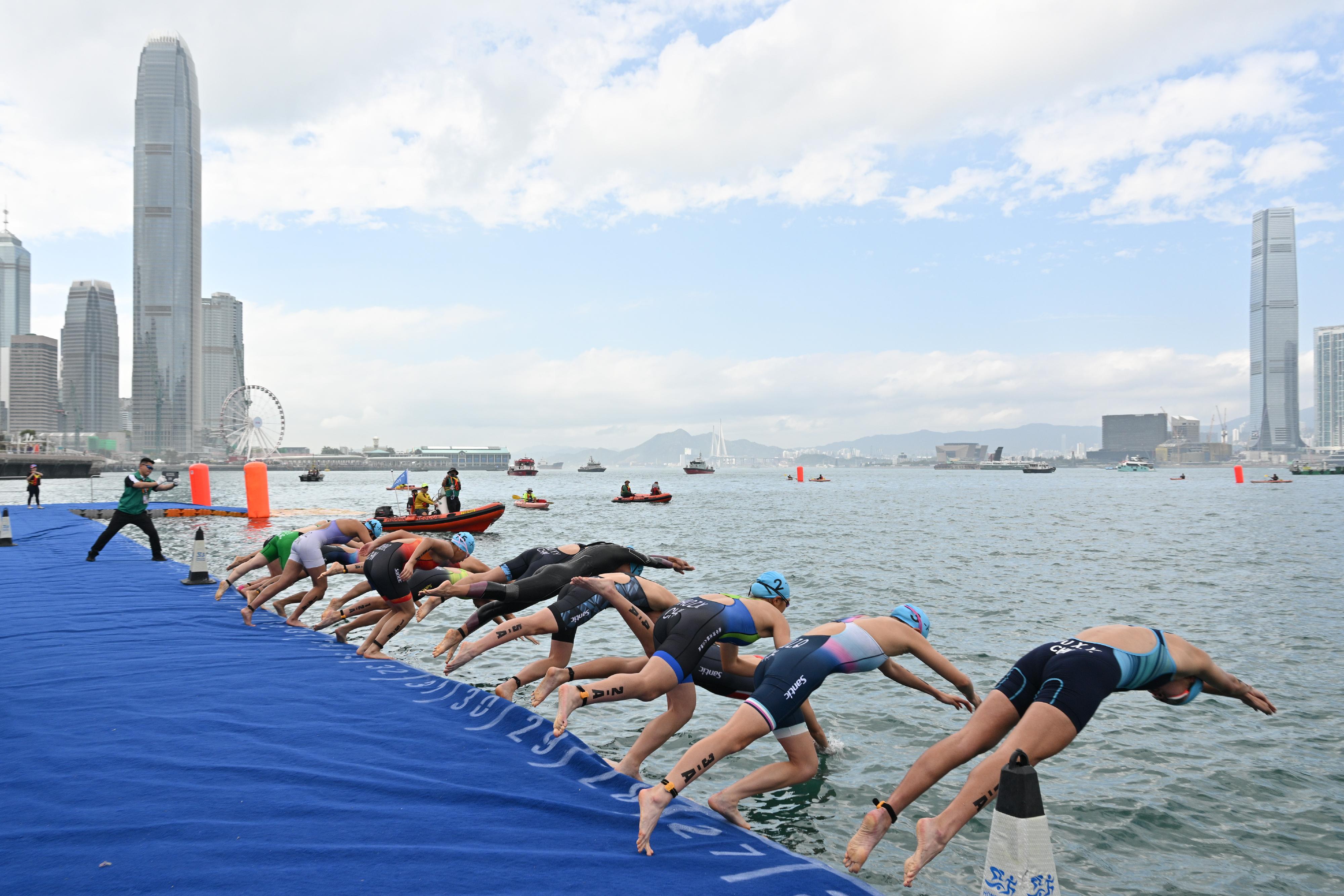 The 15th National Games Triathlon test event was held at the Central Harbourfront and Victoria Harbour today (March 2). Photo shows athletes diving into the water at the starting point to kick-off the swimming segment of the mixed relay event.