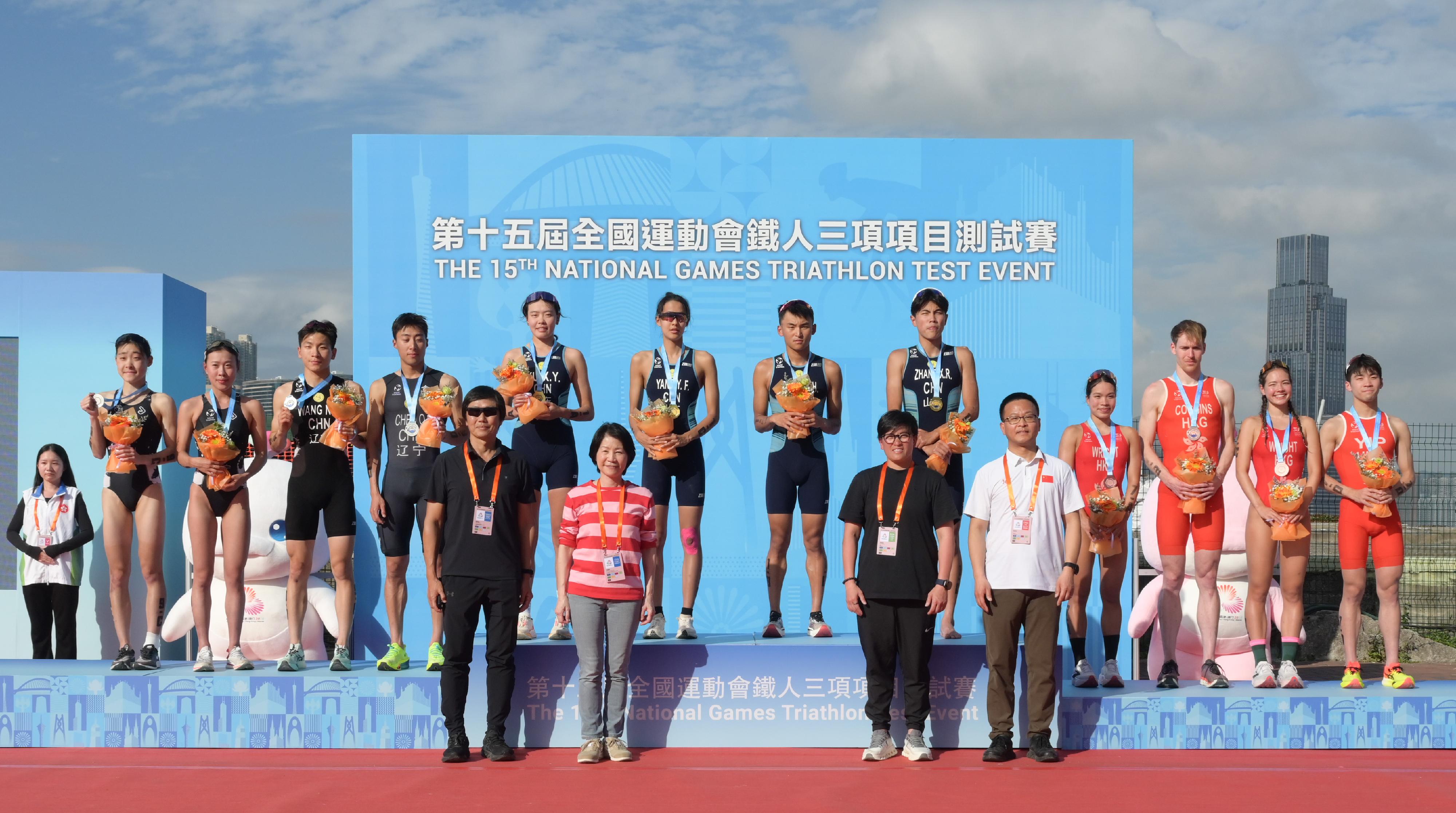 The mixed relay event of the 15th National Games Triathlon test event was held today (March 2) at the Central Harbourfront and Victoria Harbour. Photo shows the Permanent Secretary for Culture, Sports and Tourism, Ms Vivian Sum (second left, front row), the Head of the National Games Coordination Office (Hong Kong), Mr Yeung Tak-keung (first left, front row), the Secretary General of the China Triathlon Sports Association, Mr Qin Jianqiu (first right, front row) and the President of the Triathlon Association of Hong Kong China, Ms Chau Chiu-nam (second right, front row), presenting awards to the winners of the event.