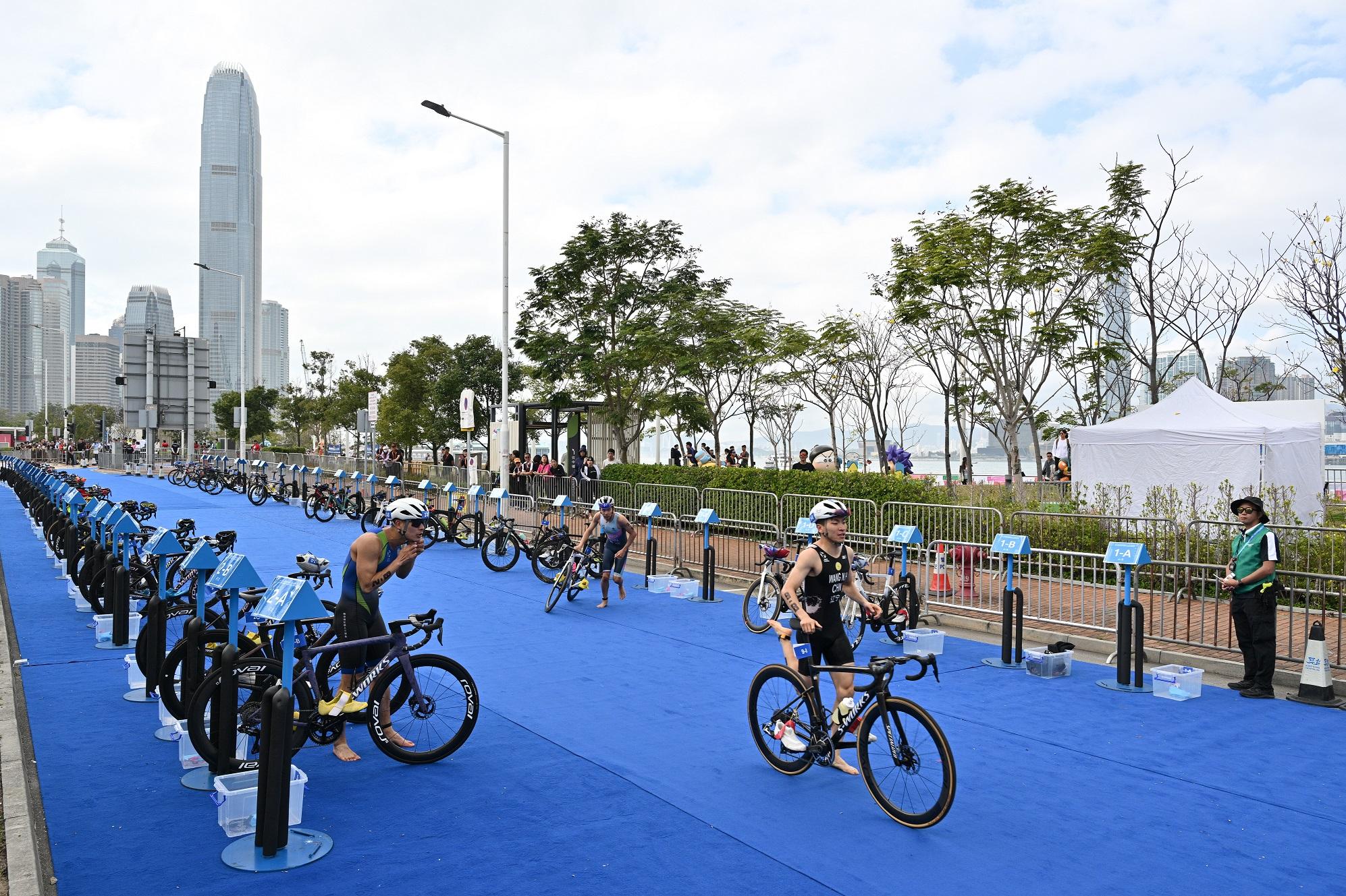 The 15th National Games Triathlon test event was held at the Central Harbourfront and Victoria Harbour today (March 2). Photo shows athletes switching from swimming to cycling at the transition area.