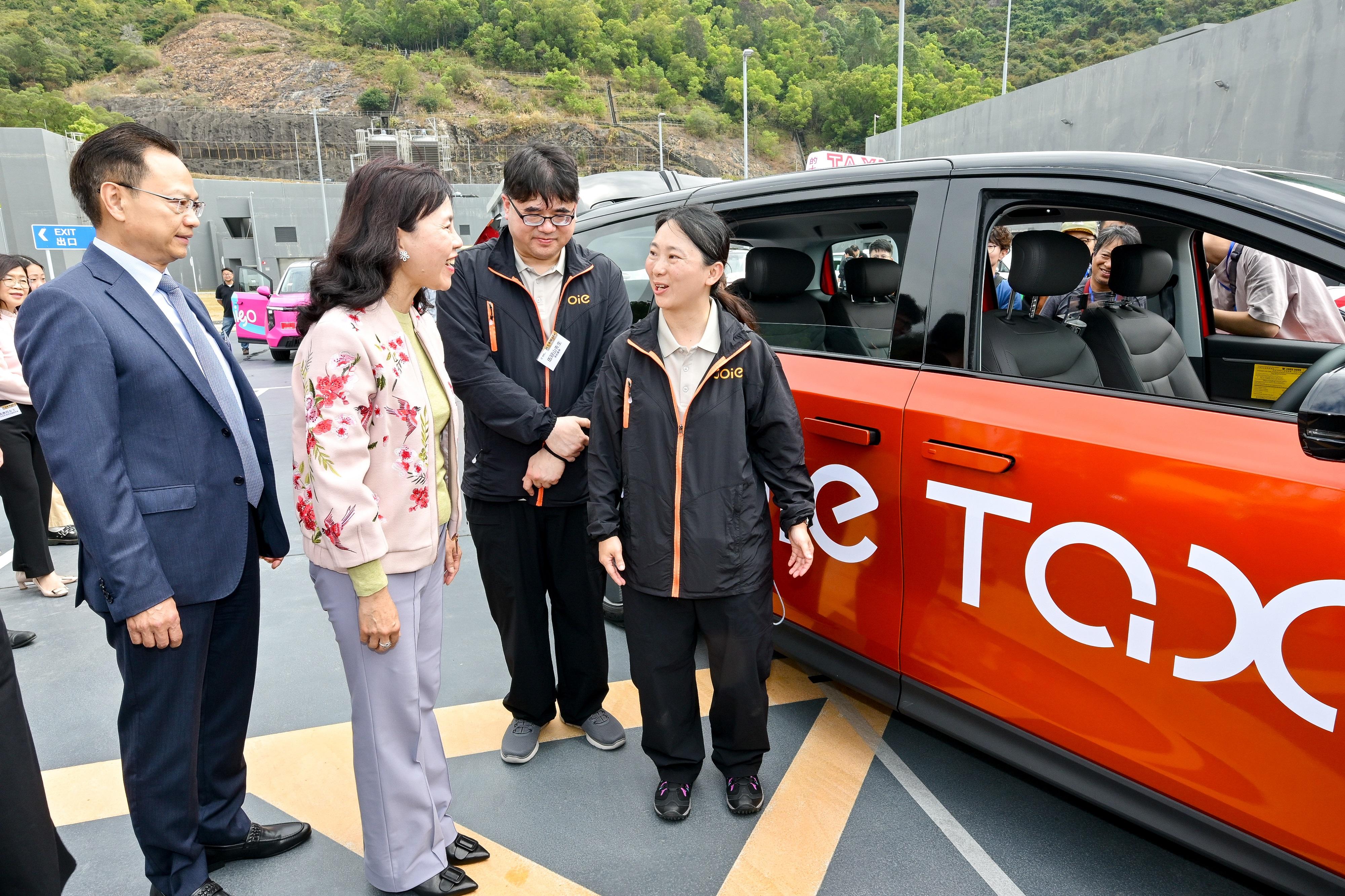 The Secretary for Transport and Logistics, Ms Mable Chan, today (March 3) attended the Taxi Fleet Launching Ceremony. The five selected taxi fleet operators will soon commence service gradually. Photo shows Ms Chan (second left) looking at a Joie fleet taxi operated by Tai Wo Management Limited.