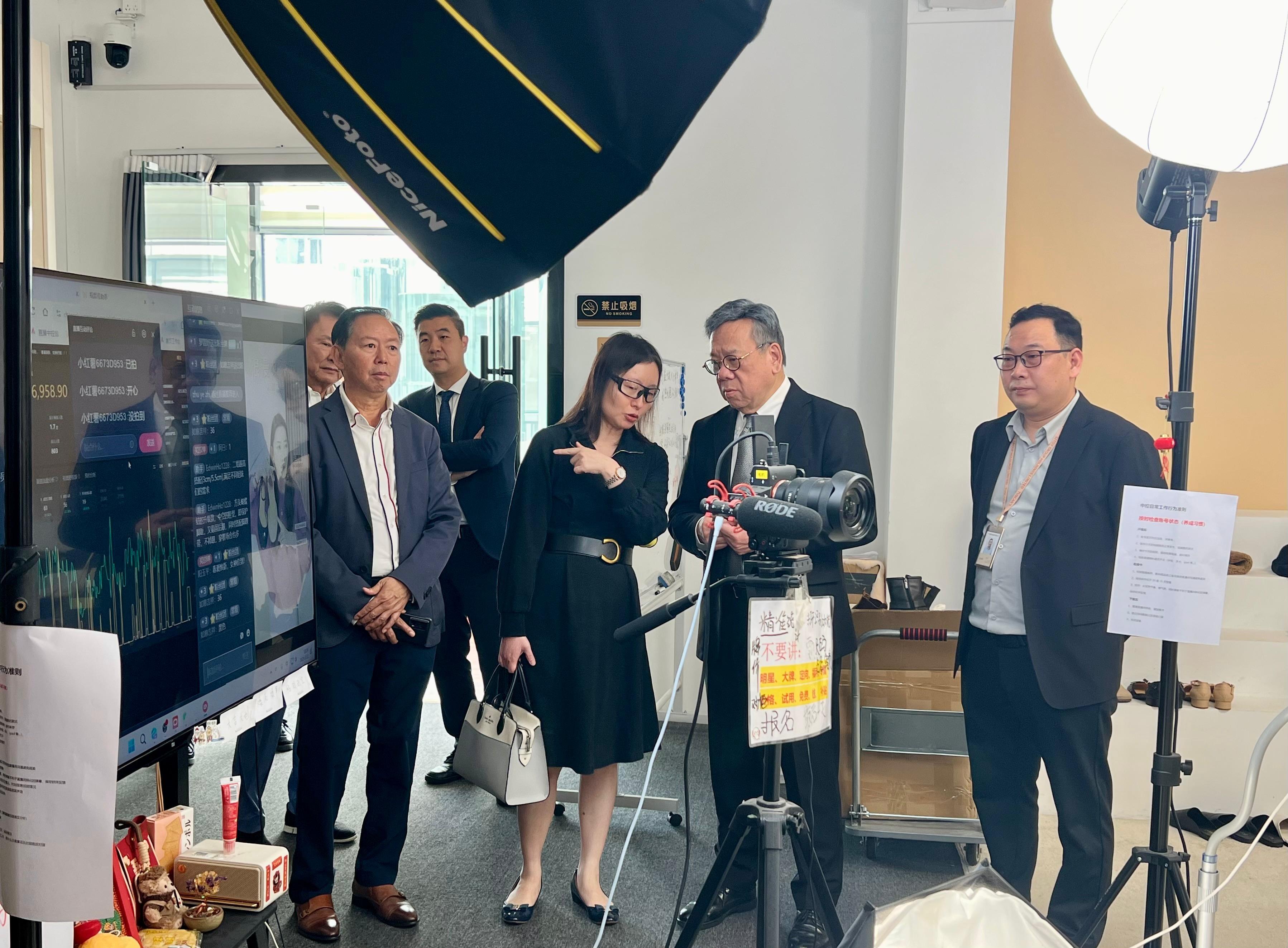 The Secretary for Commerce and Economic Development, Mr Algernon Yau, visited a large-scale Hong Kong enterprise specialising in handbags and leather goods in Dongguan today (March 11). Photo shows Mr Yau (second right) touring the e-commerce live streaming centre there to learn about the process and marketing strategies of live streaming e-commerce.