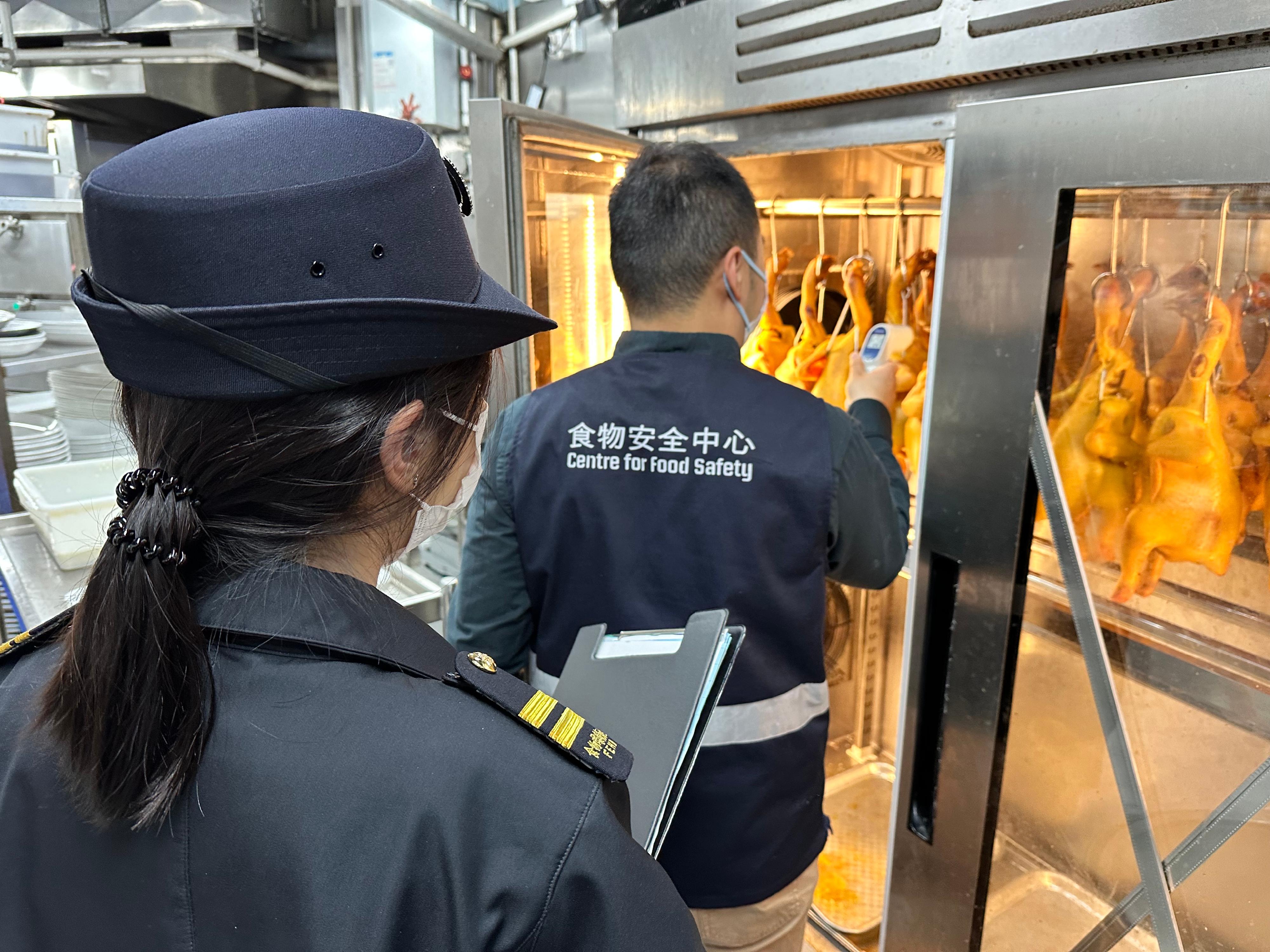 The Food and Environmental Hygiene Department (FEHD) continues to intensify inspections of food premises to safeguard food safety. Photo shows officers of the Centre for Food Safety and the Environmental Hygiene Branch of the FEHD inspecting a shop selling siu mei to ensure food storage, preparation and hygiene comply with safety standards and relevant legislation.