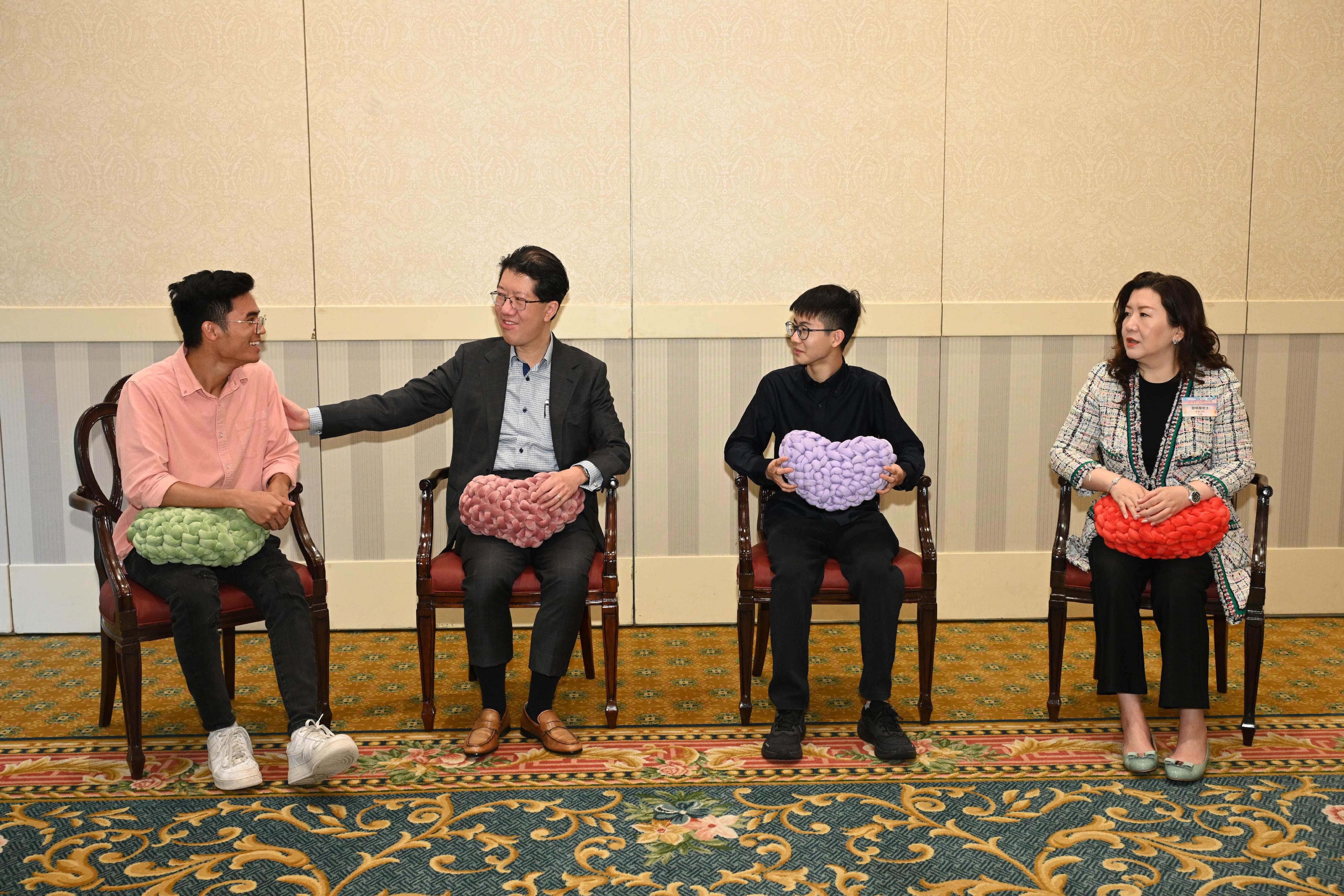 The Director of Social Welfare, Mr Edward To (second left) and the Chairman of the Board of Directors of the Tung Wah Group of Hospitals, Ms Mandy Tang (first right), chat with the awardees of the Best Achievement Awards at the 2025 Aspiring Youth Recognition Ceremony today (March 15).
