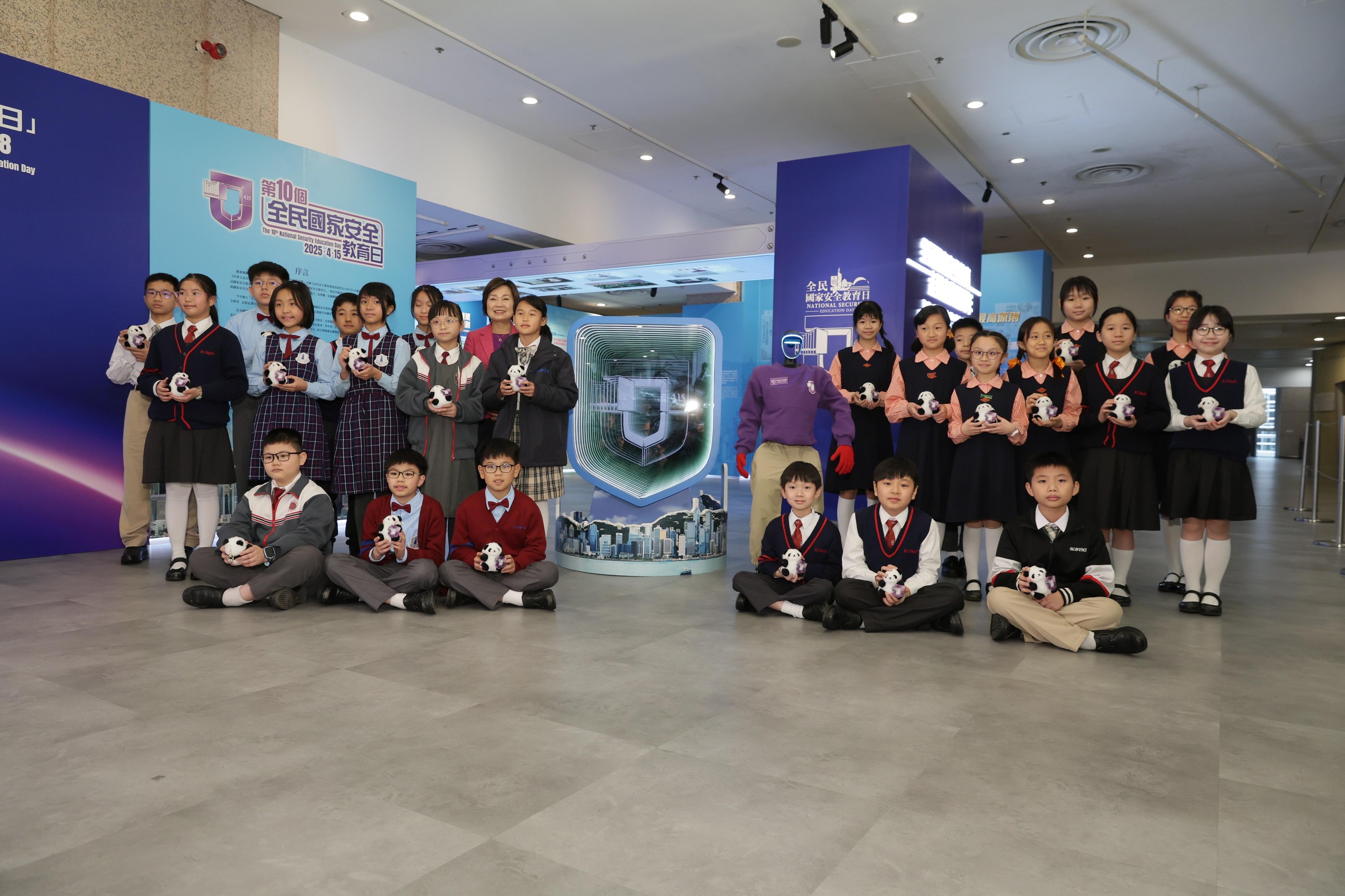 The Secretary for Education, Dr Choi Yuk-lin (back row, fifth left), is pictured with students and the robotic docent at the opening ceremony of the 10th National Security Education Day thematic exhibition today (March 18).