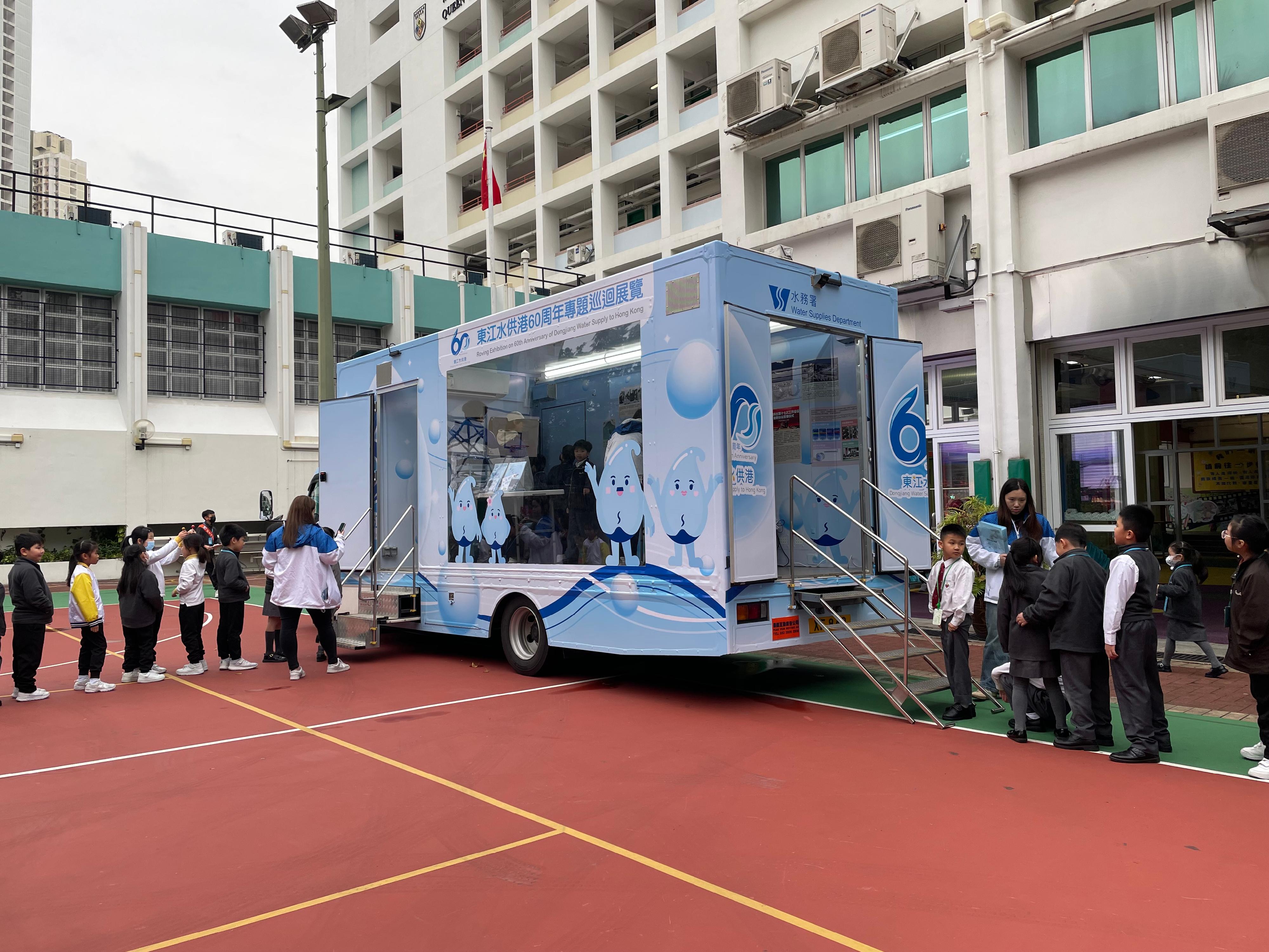To raise public awareness of the history and the current situation of Dongjiang water supply to Hong Kong, the Water Supplies Department arranged for a mobile exhibition vehicle to tour different districts and schools starting from today (March 22) until April 13. Photo shows students visiting the mobile exhibition vehicle.