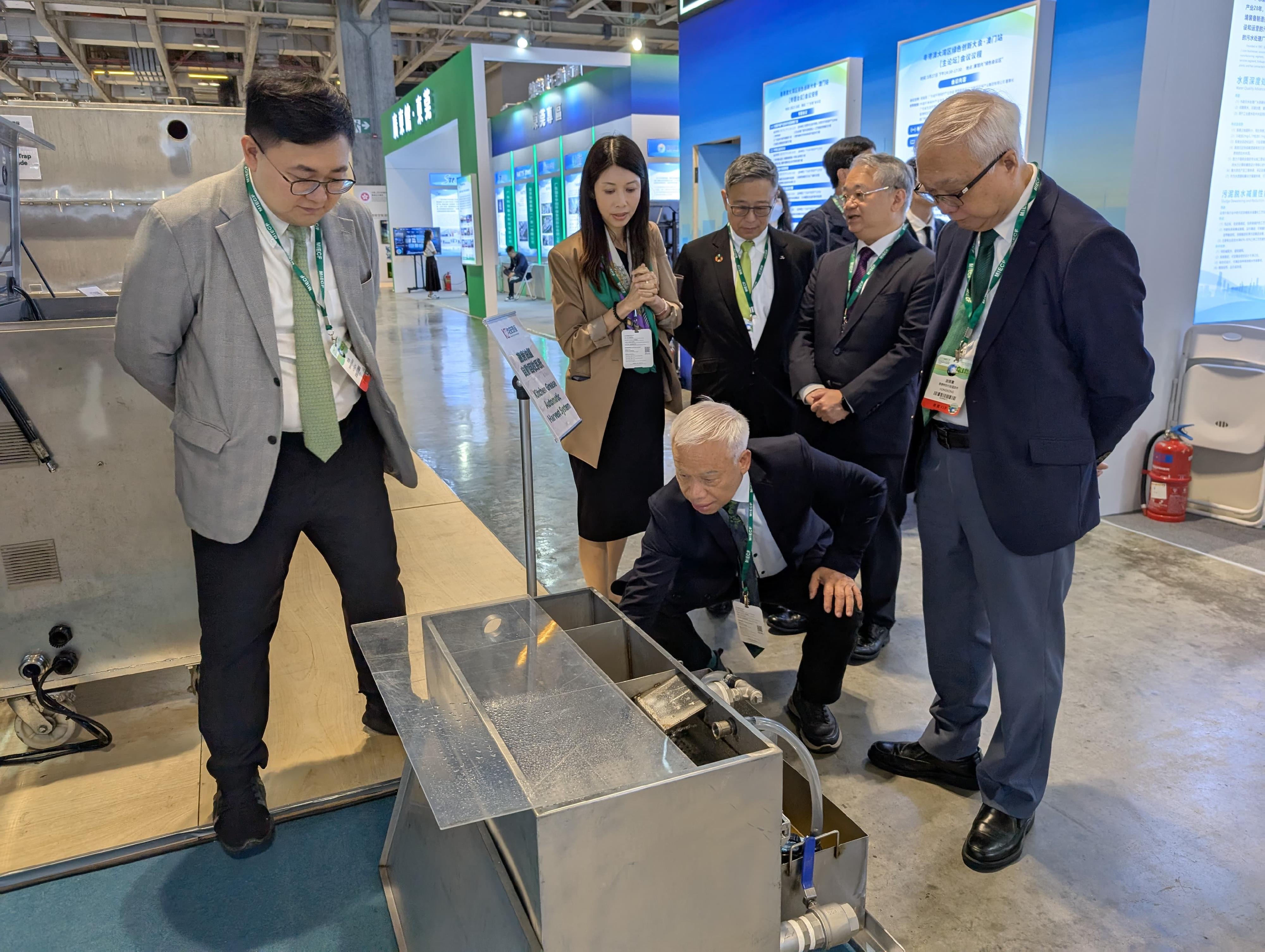 The Secretary for Environment and Ecology, Mr Tse Chin-wan, today (March 27) attended the 2025 Macao International Environmental Co-operation Forum & Exhibition in Macao. Photo shows Mr Tse (first right) and the Director of Environmental Protection, Dr Samuel Chui (second right), exchanging views with a Macao exhibitor to understand the principle and operation of a kitchen grease automatic harvest system.
