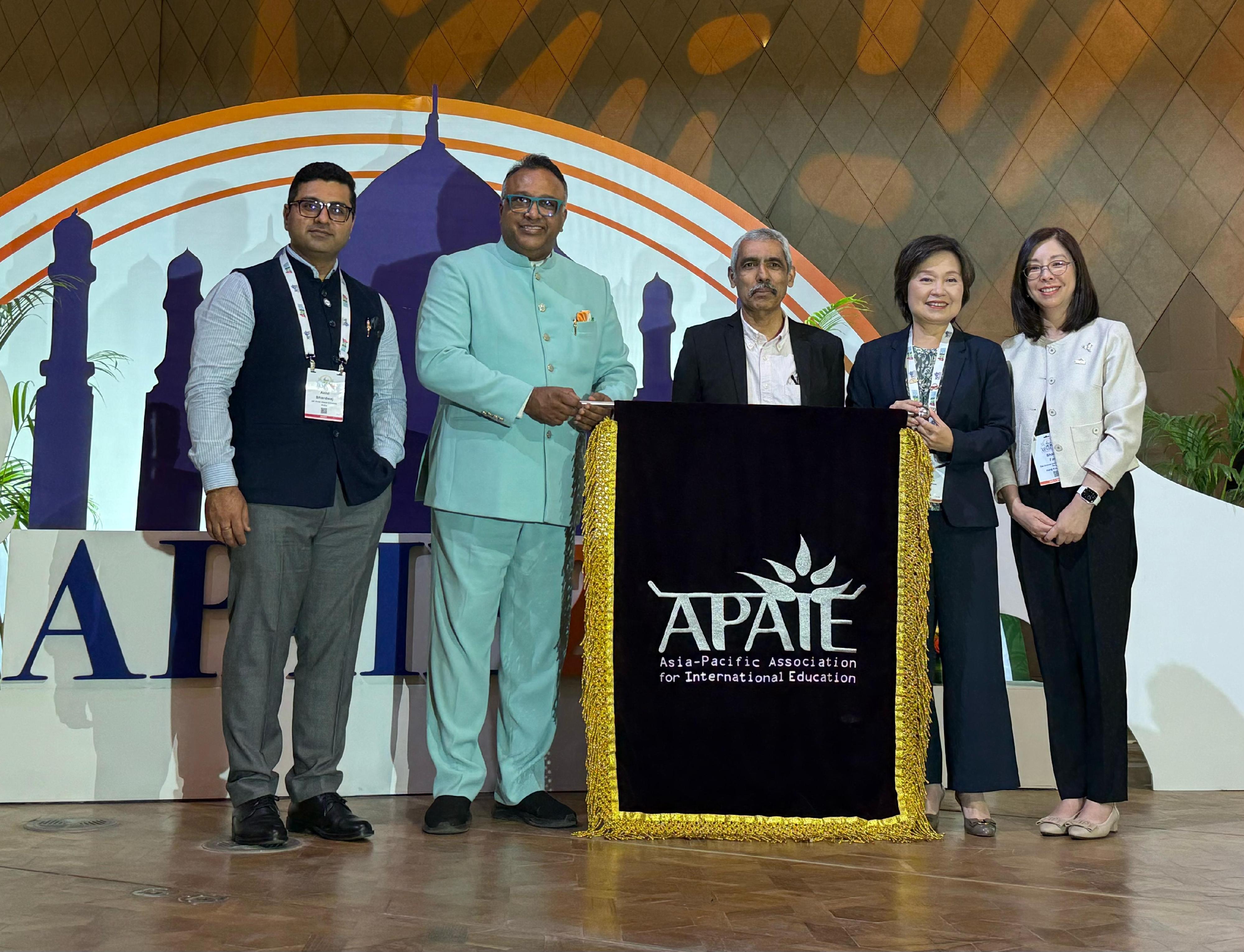 The Secretary for Education, Dr Choi Yuk-lin, attended the Asia-Pacific Association for International Education (APAIE) 2025 Conference and Exhibition in Delhi, India, on March 27 (Delhi time) and received the APAIE flag from the President of the APAIE, officially announcing that the next APAIE Conference and Exhibition will be held in Hong Kong. Photo shows Dr Choi (second right); the Director of Academic Links of the Chinese University of Hong Kong, Ms Shally Fan (first right); the President of the APAIE, Professor Venky Shankararaman (centre); and representatives of India, the host of this year’s APAIE Conference, at the ceremony.