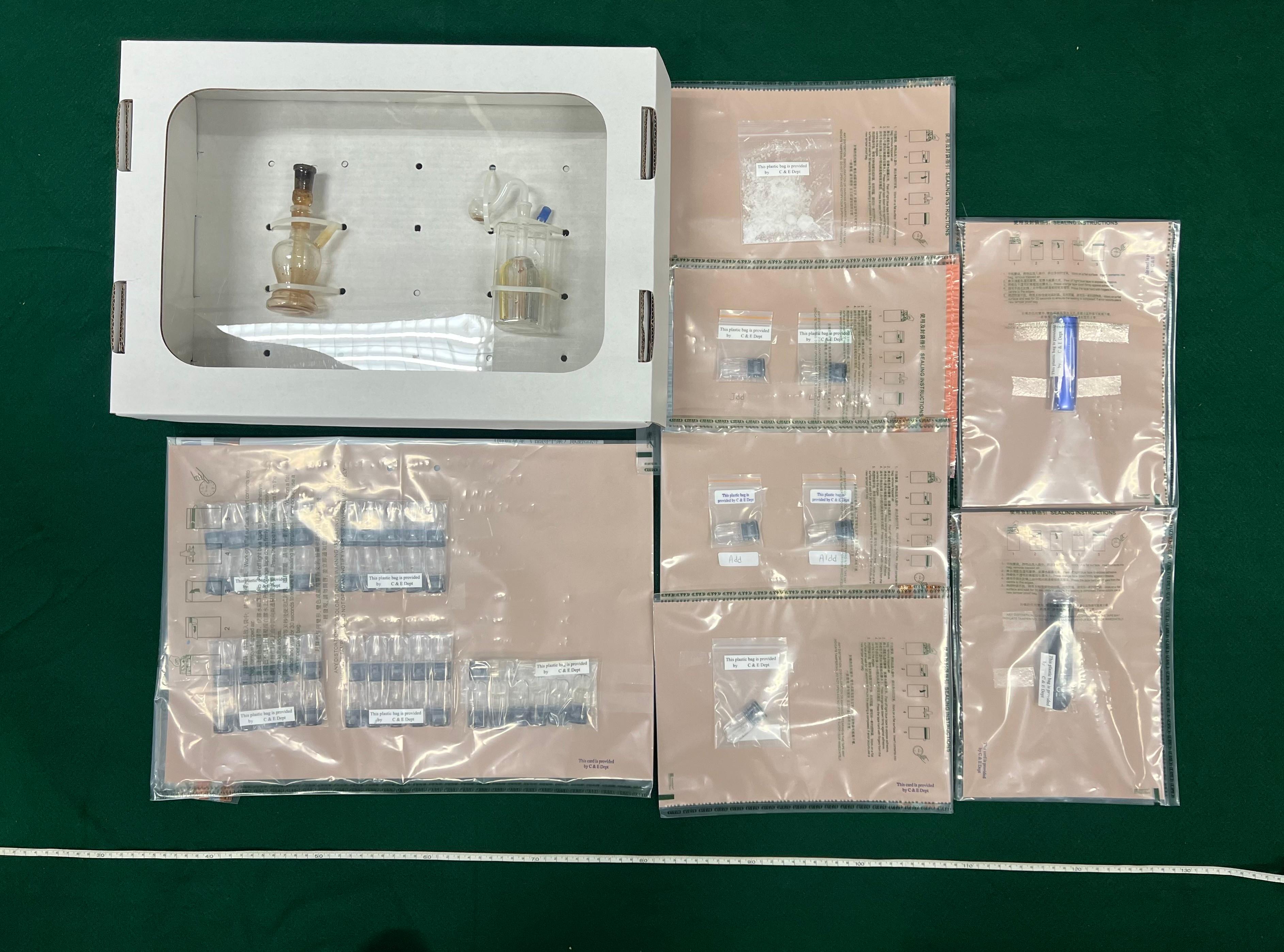 Hong Kong Customs yesterday (March 31) in Tsing Yi seized 52 suspected "space oil drug" capsules, about 10 grams of suspected methamphetamine, two vape sticks, a batch of drug-inhaling apparatus and drug packaging paraphernalia with a total estimated market value of about $24,000. Three men were arrested. Photo shows the suspected dangerous drugs, vape sticks and drug-inhaling apparatus seized.