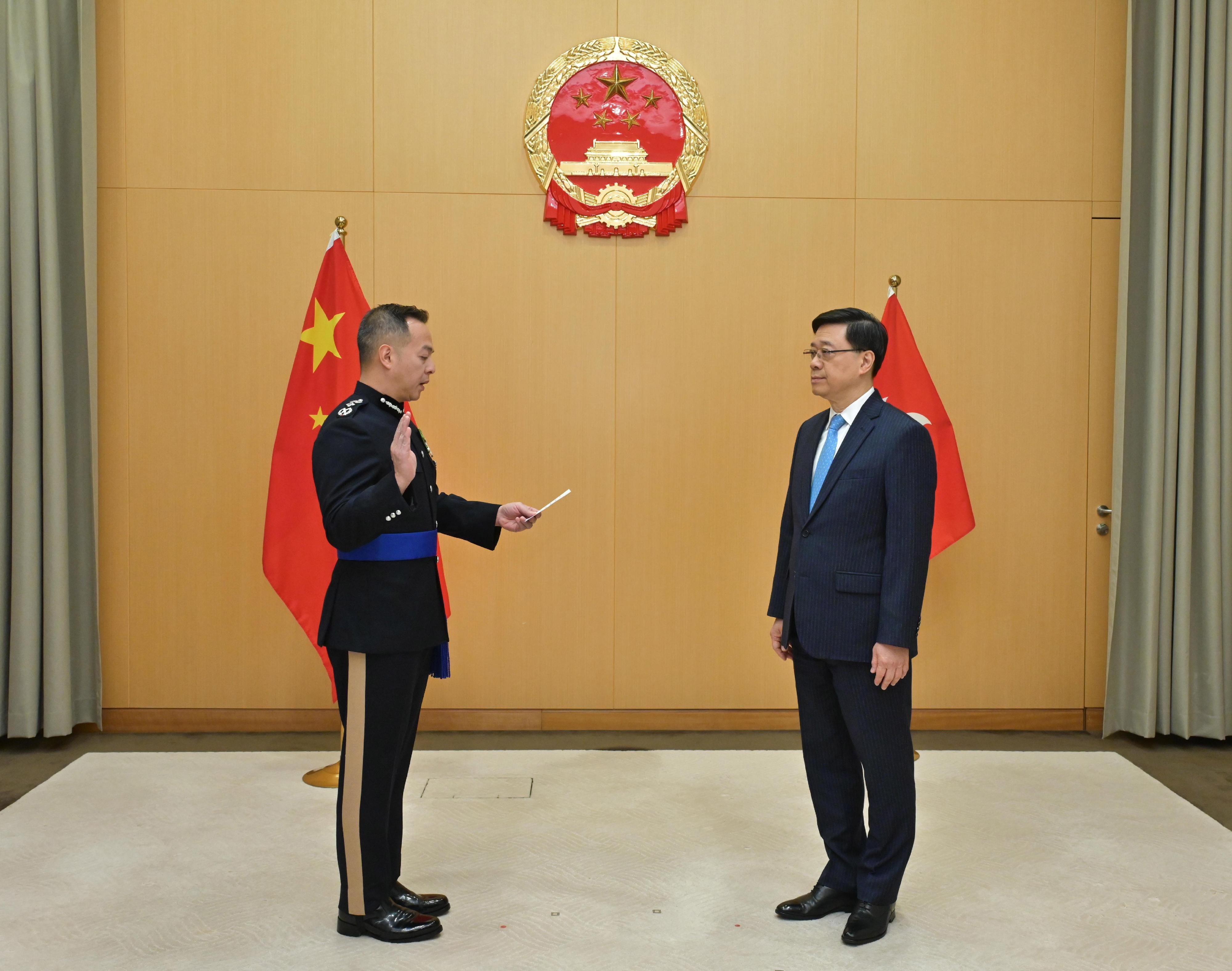 The new Commissioner of Police, Mr Chow Yat-ming, Joe (left), takes the oath of office, witnessed by the Chief Executive, Mr John Lee (right), today (April 2).