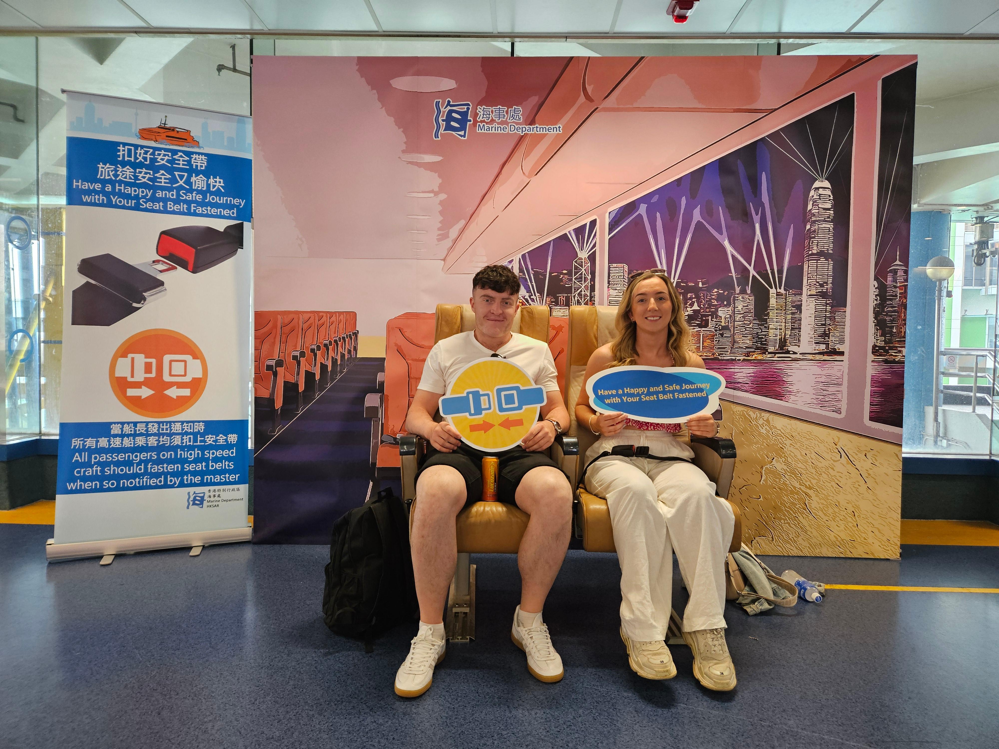 The Marine Department today (April 3) set up a large backdrop of a beautiful Hong Kong scene and installed genuine cabin seats at the waiting lounge of the Hong Kong-Macau Ferry Terminal in Sheung Wan. Photo shows passengers trying out fastened seat belts as if they are on board a high-speed craft.