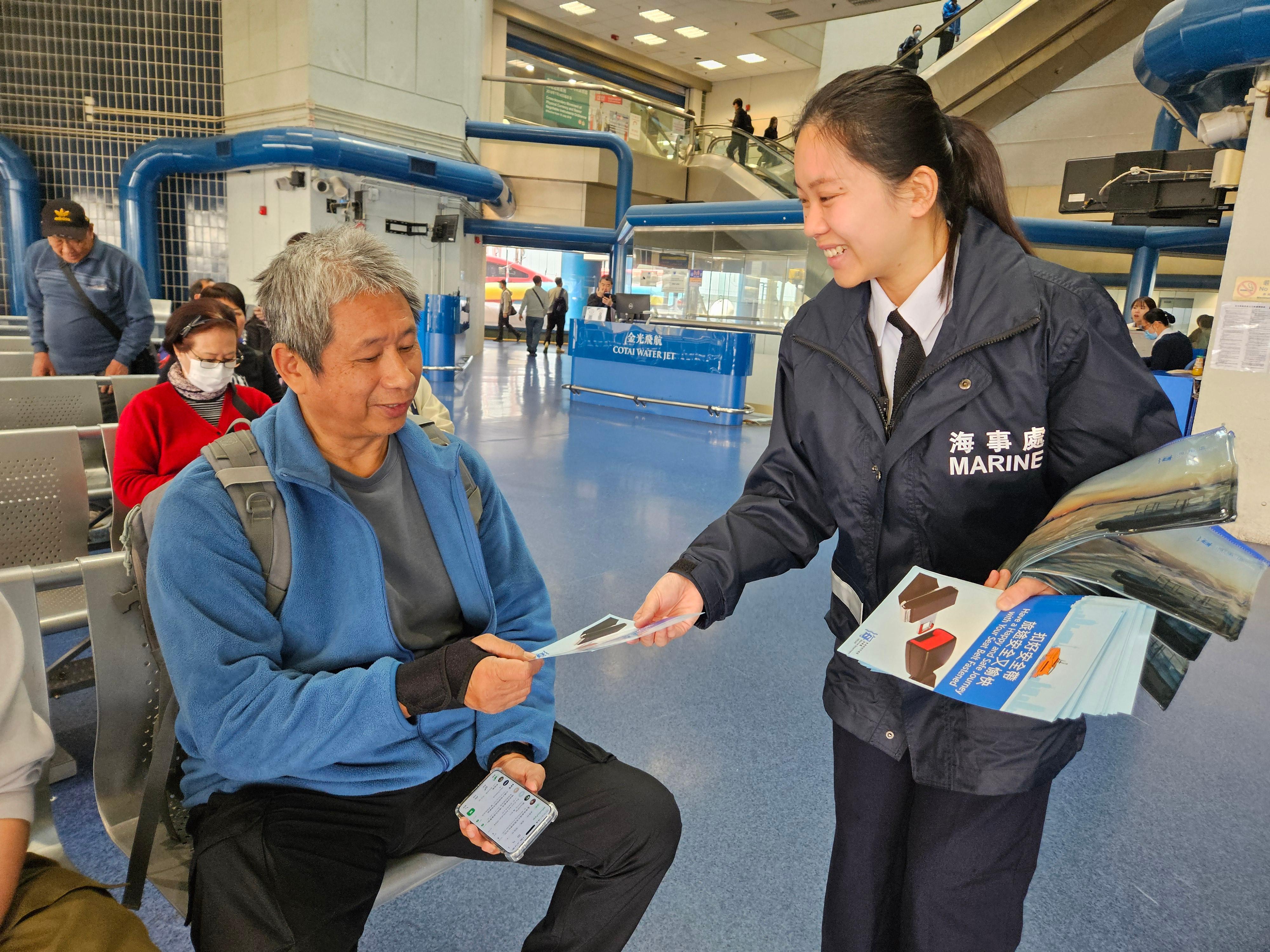 海事處人員今日（四月三日）在上環港澳碼頭候船室向乘客派發宣傳單張，呼籲乘客適時扣上安全帶，以保障海上旅途的安全。
