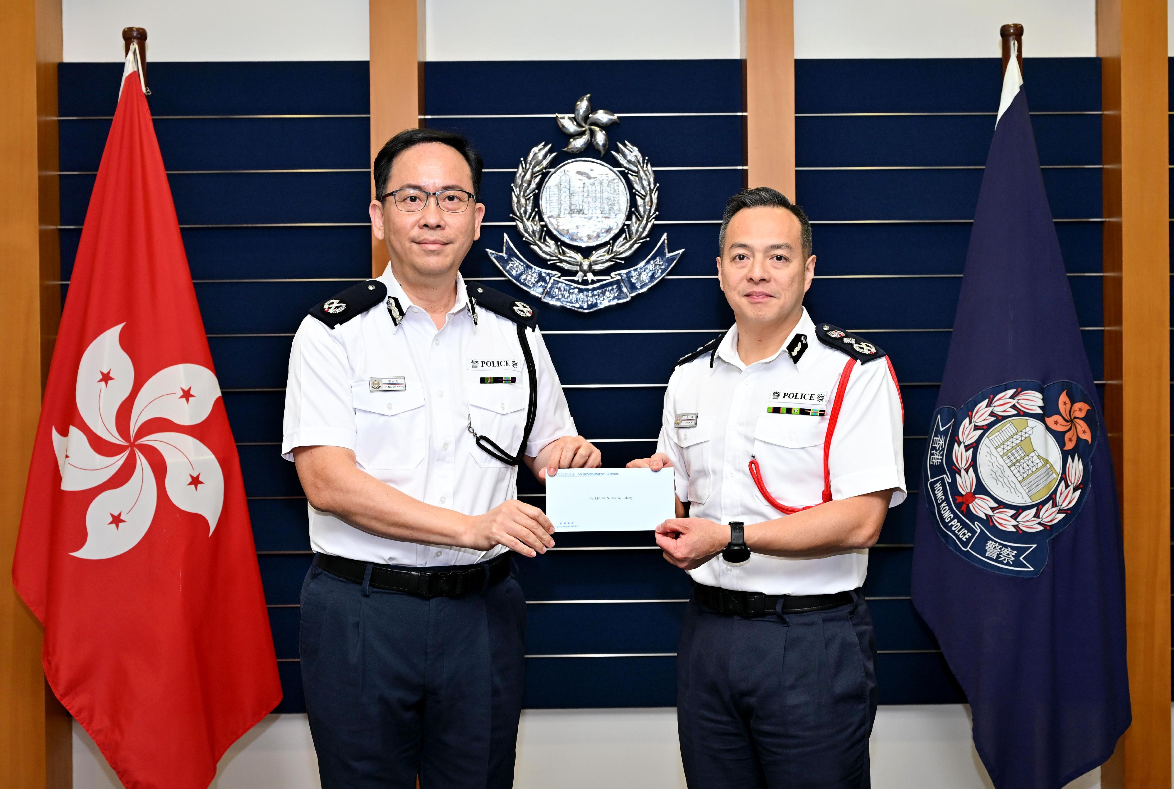 警務處處長周一鳴（右）頒授委任狀予新委任香港輔助警察隊總監梁世光（左）。