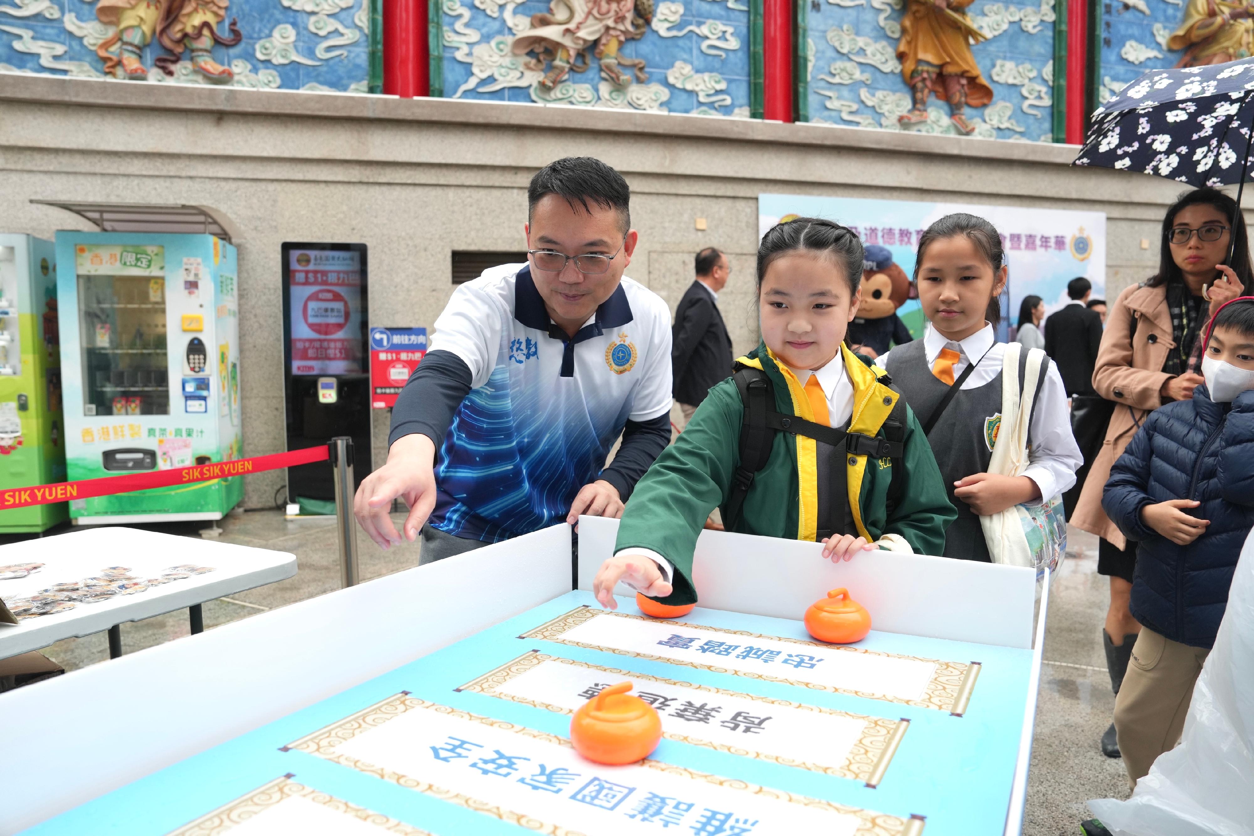 The Correctional Services Department held an animation launch ceremony and carnival today (April 5) at the Wong Tai Sin Temple to promote national security and moral education among the public. Photo shows a student participating in a booth game.