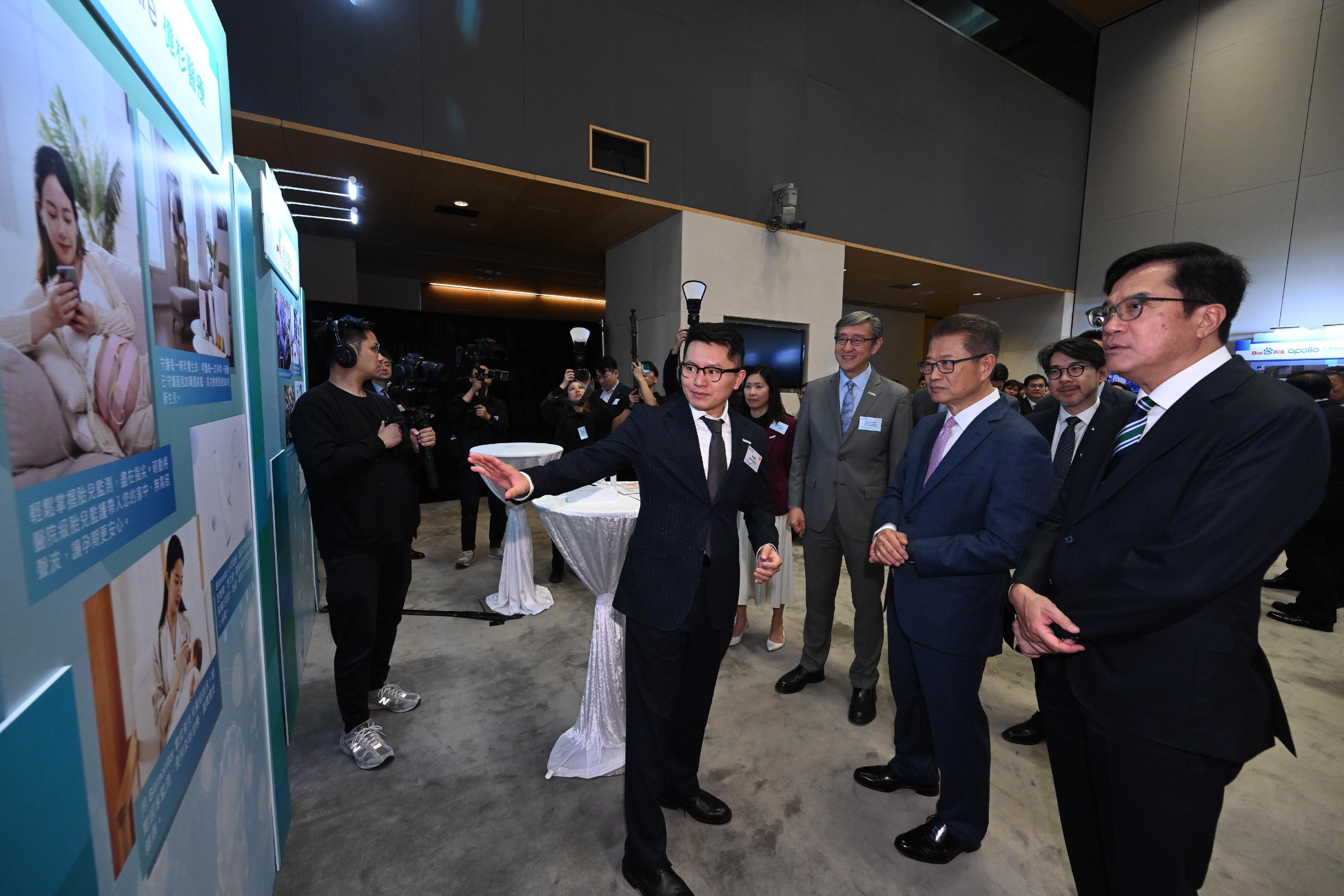 The Financial Secretary, Mr Paul Chan, attended the OASES Enterprises Signing Ceremony today (April 8). Photo shows Mr Chan (second right) interacting with a representative of the strategic enterprise. Looking on is the Deputy Financial Secretary, Mr Michael Wong (first right). 