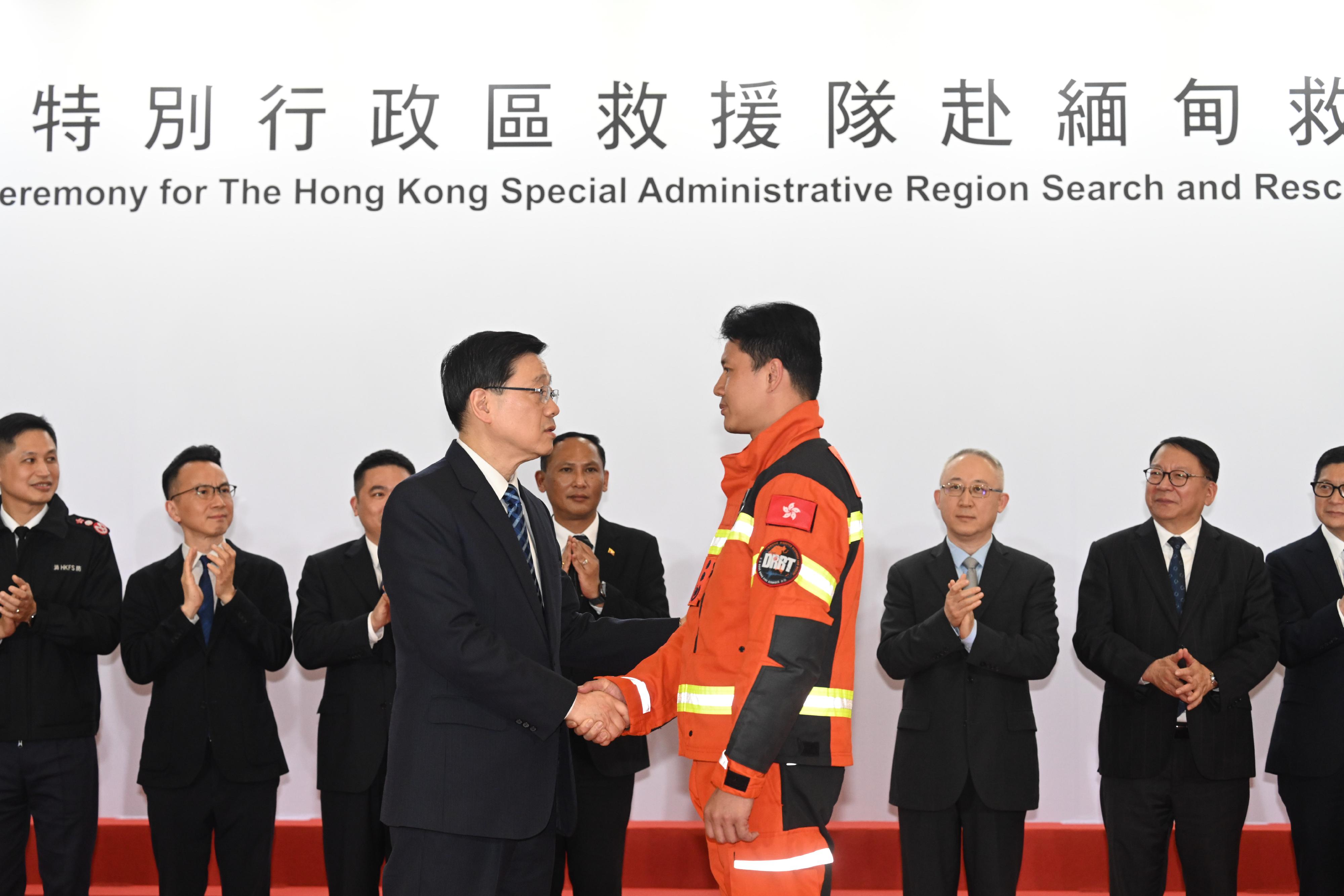 The Chief Executive, Mr John Lee, attended the Welcome Ceremony for the Hong Kong Special Administrative Region (HKSAR) Search and Rescue Team returning from Myanmar today (April 9). Photo shows Mr Lee (front row, left) shaking hands with a member of the HKSAR Search and Rescue Team at the ceremony.