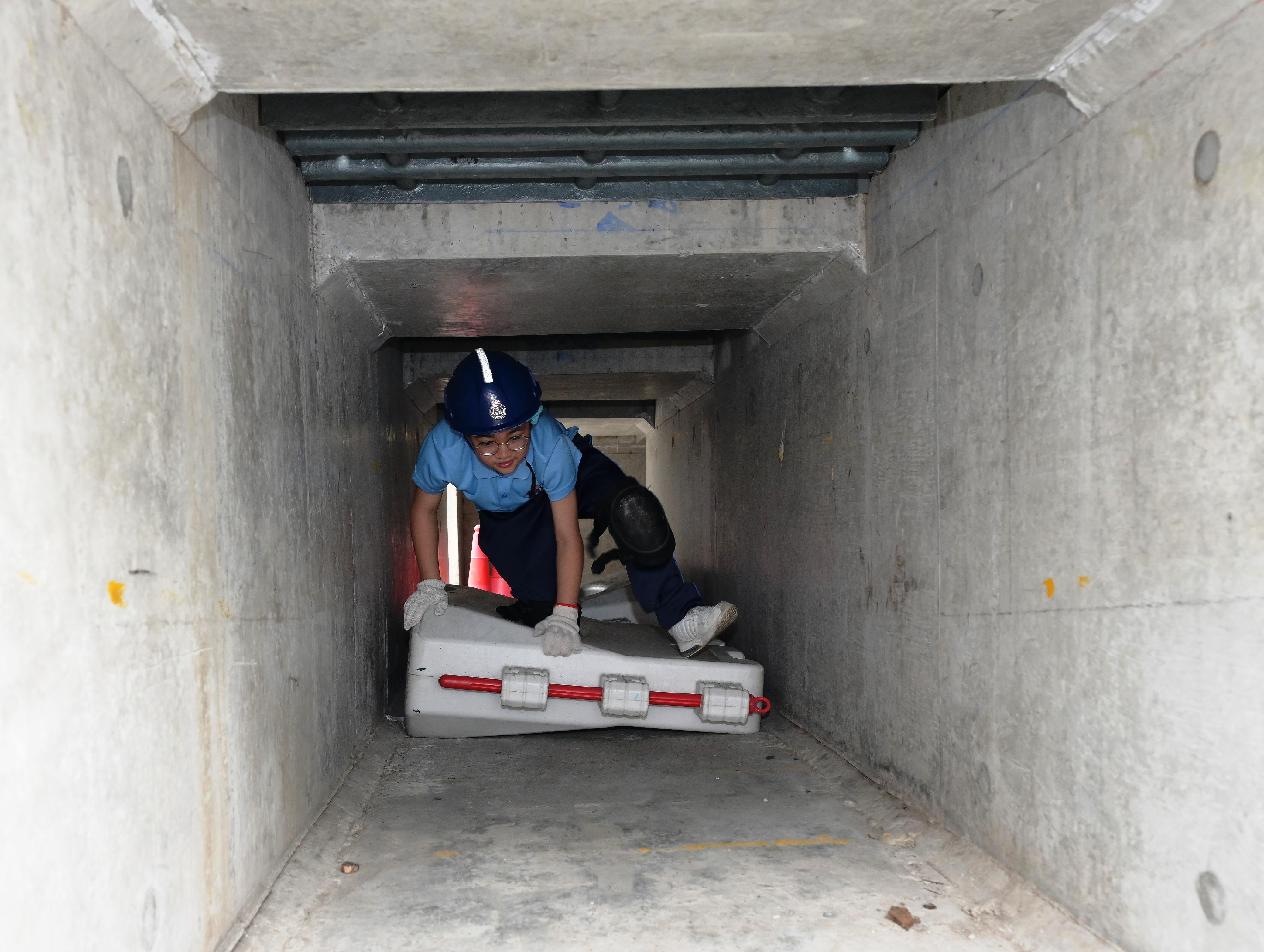 The Civil Aid Service held an open day at its headquarters today (April 12) to promote National Security Education Day. Photo shows members of the public experiencing confined space accident handling by walking through a dark tunnel to increase public awareness of emergency response.
