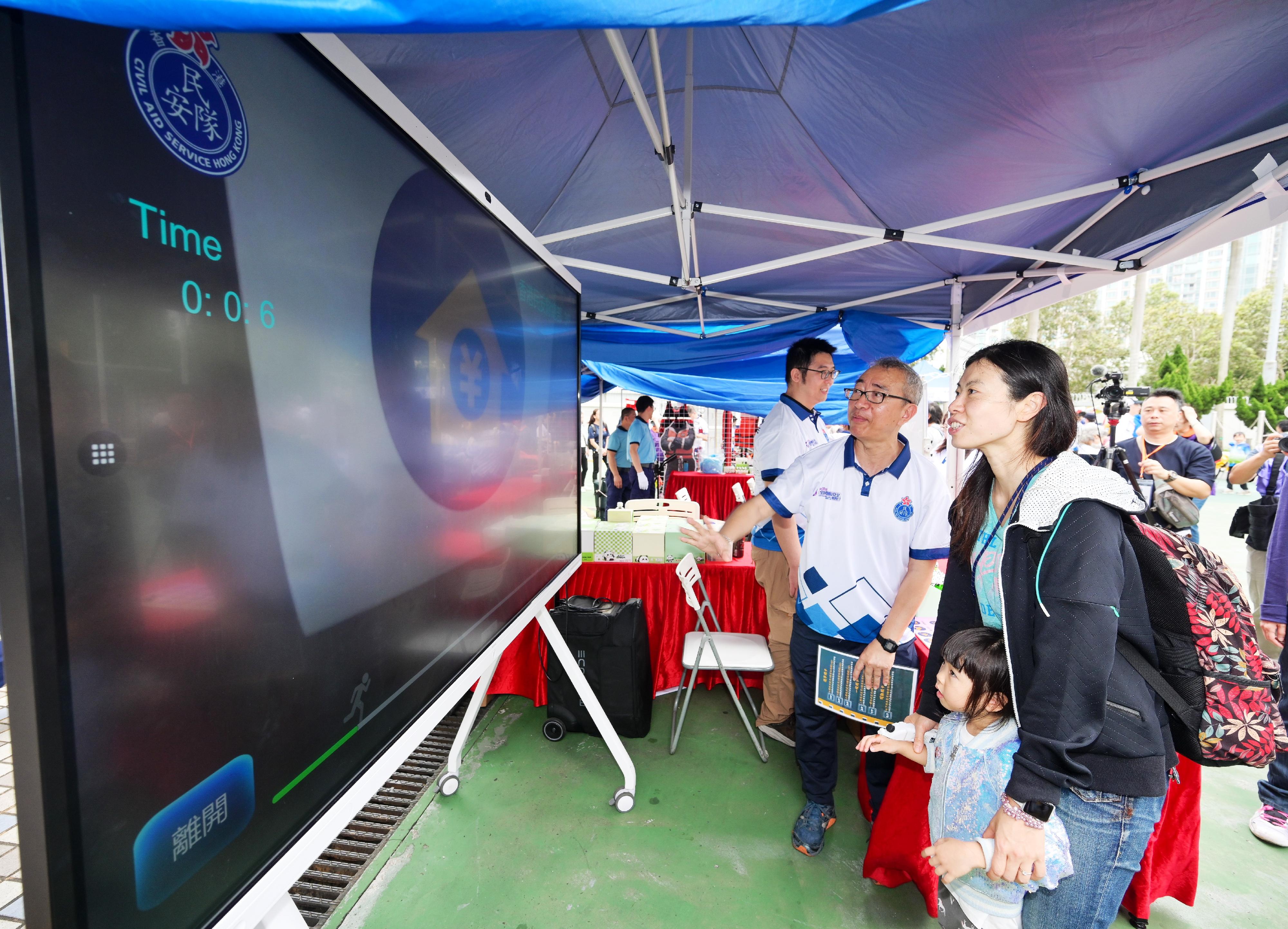 The Civil Aid Service held an open day at its headquarters today (April 12) to promote National Security Education Day. Photo shows members of the public enjoying a virtual reality experience.
