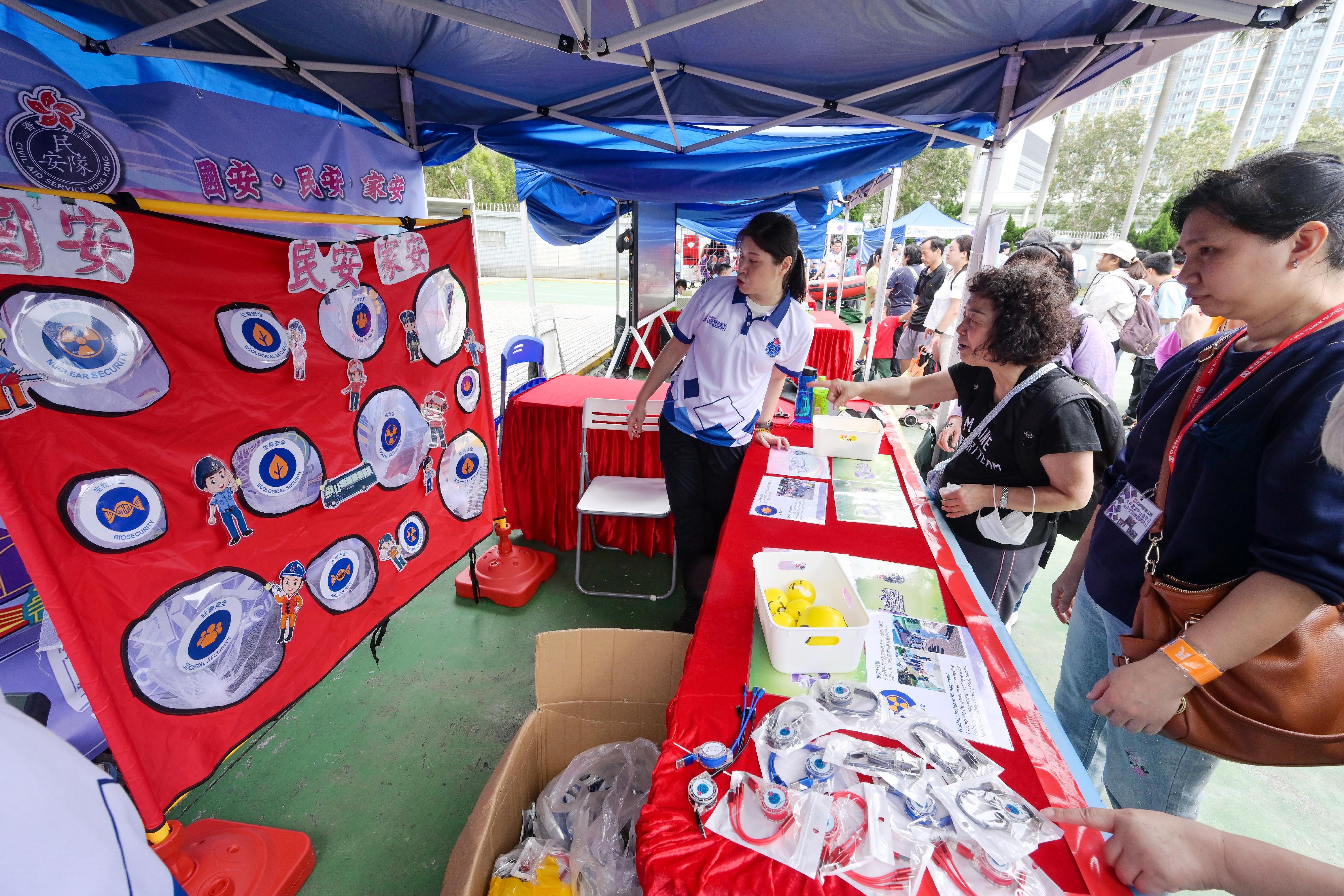 The Civil Aid Service held an open day at its headquarters today (April 12) to promote National Security Education Day. Photo shows members of the public visiting game booths.
