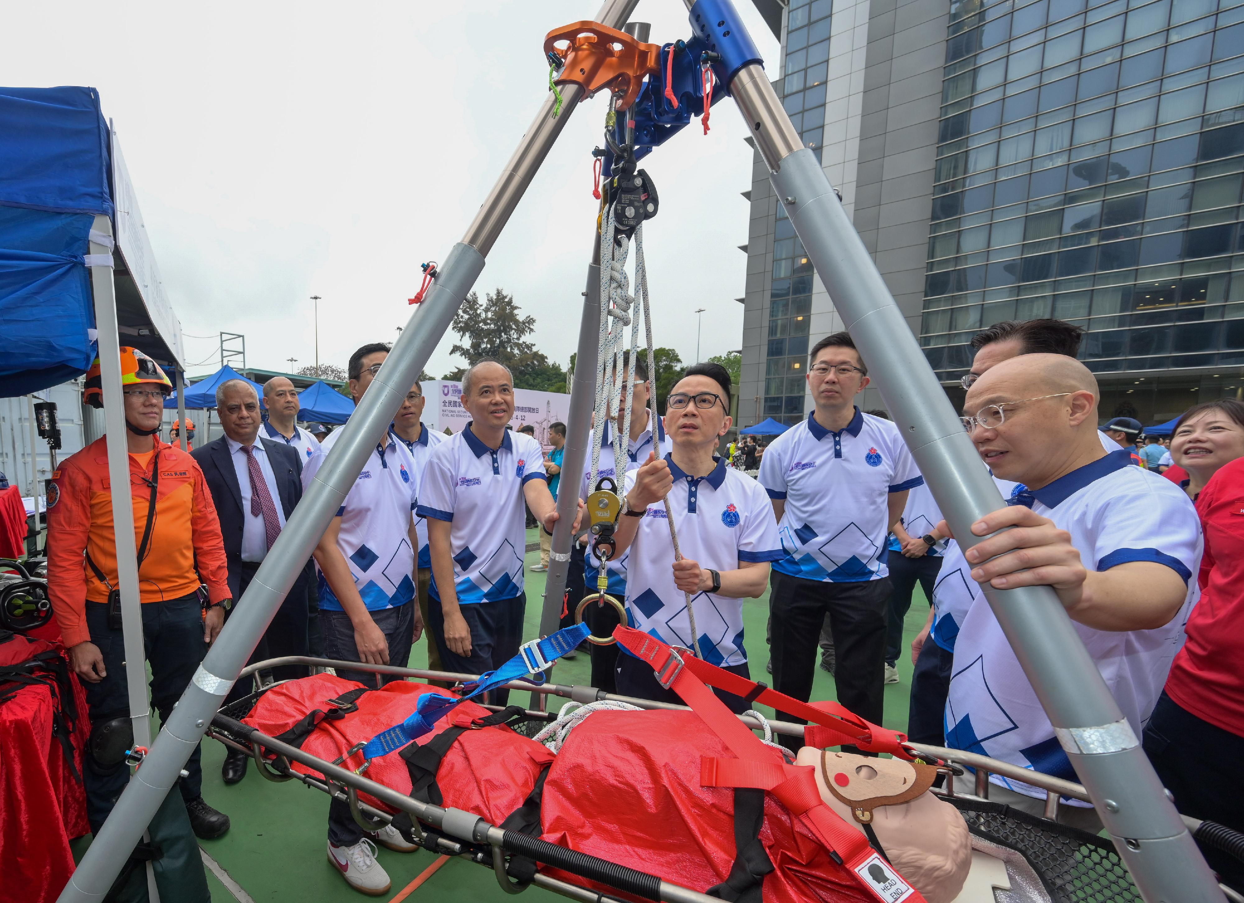 The Civil Aid Service held an open day at its headquarters today (April 12) to promote National Security Education Day. Photo shows the Permanent Secretary for Security, Mr Patrick Li, (fourth right), touring the game booth.