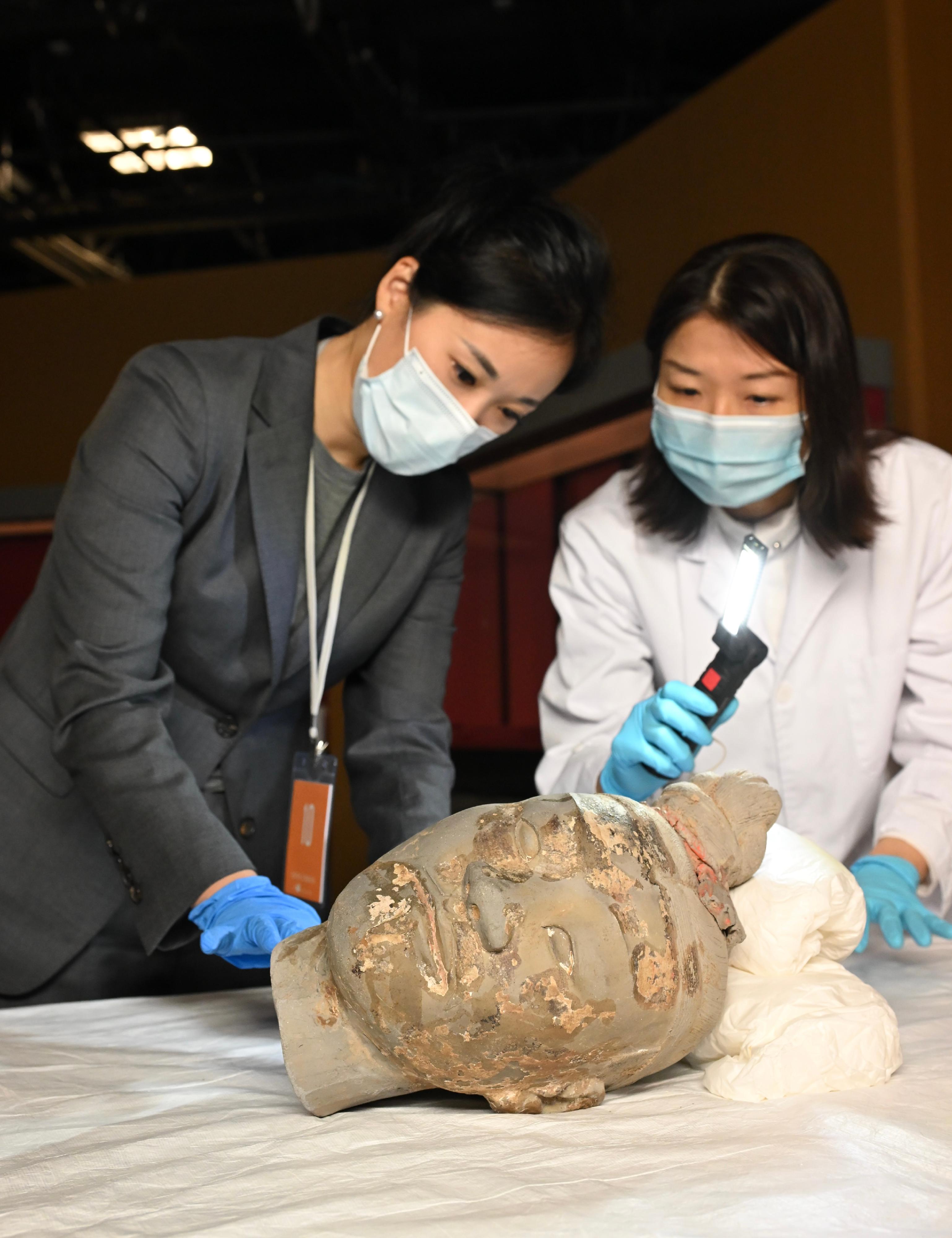 "The Hong Kong Jockey Club Series: The Great Unity - Civilisation of the Qin and Han Dynasties in Shaanxi Province" exhibition will be held at the Hong Kong Museum of History from April 16 to July 7. Photo shows a museum conservator from the Leisure and Cultural Services Department and an expert from Shaanxi performing condition inspection on the head of Terracotta Kneeling Archer, a grade-one national treasure from a collection of the Emperor Qinshihuang’s Mausoleum Site Museum.