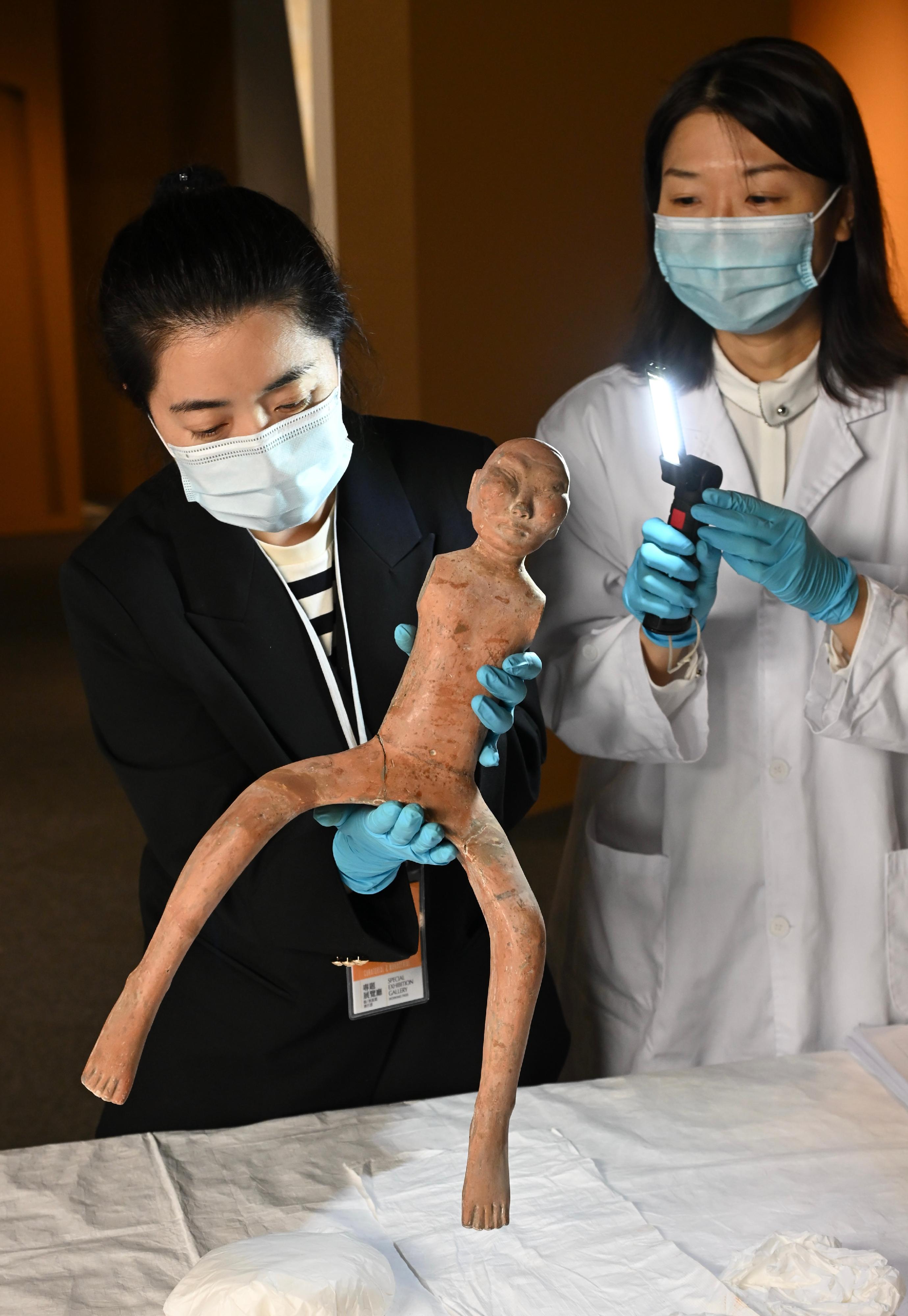 "The Hong Kong Jockey Club Series: The Great Unity - Civilisation of the Qin and Han Dynasties in Shaanxi Province" exhibition will be held at the Hong Kong Museum of History from April 16 to July 7. Photo shows a museum conservator from the Leisure and Cultural Services Department and an expert from Shaanxi performing condition inspection on a naked cavalry figurine from the Han dynasty, unearthed from the burial pits in Southern district of Han Yangling Mausoleum of Xianyang City in Shaanxi Province from the collection of Hanyangling Museum.