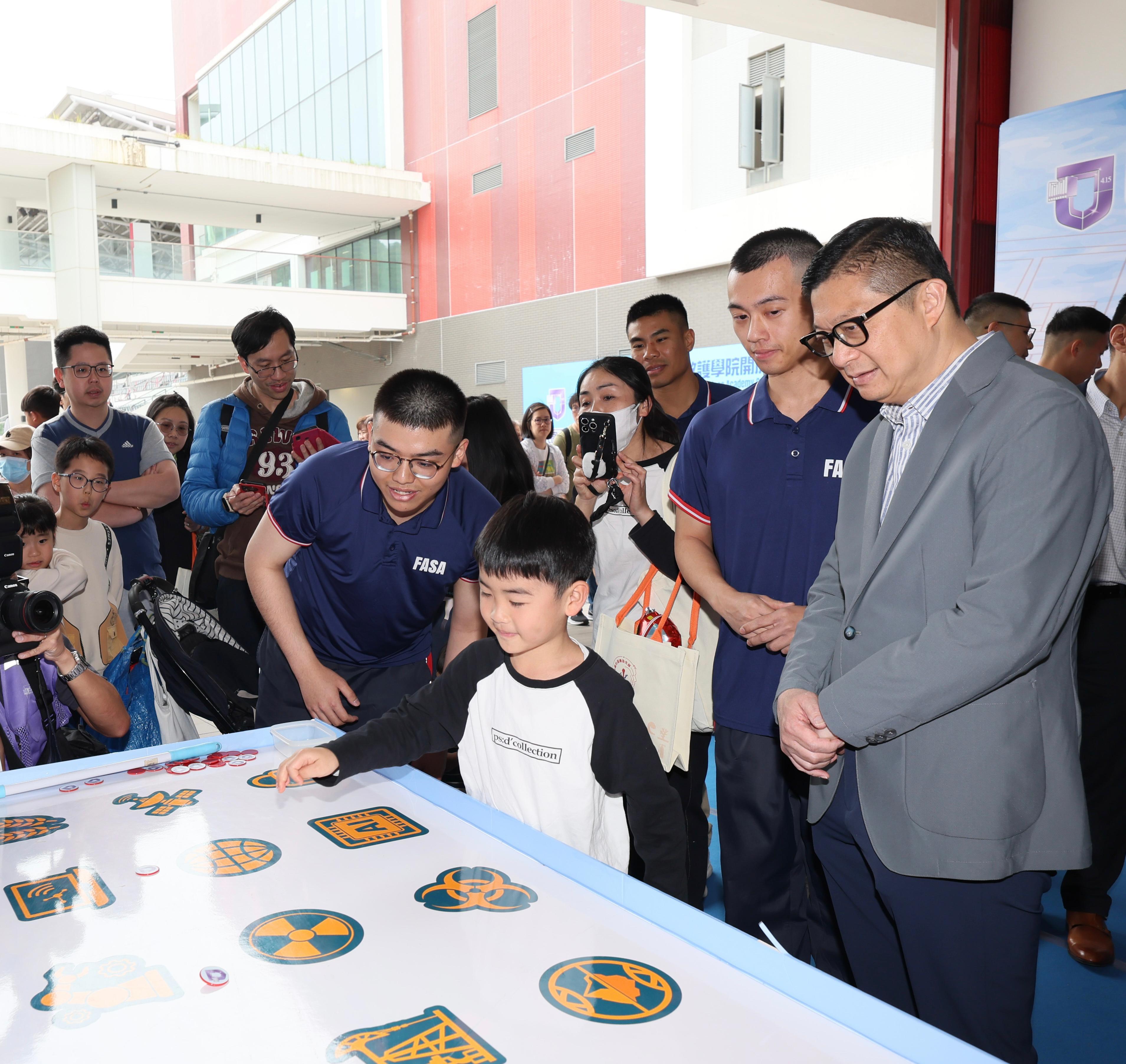 In response to and in support of the 10th National Security Education Day, the Fire Services Department held an open day today (April 13) at the Fire and Ambulance Services Academy in Tseung Kwan O. Photo shows the Secretary for Security, Mr Tang Ping-keung (first right), visiting a national security education game booth.