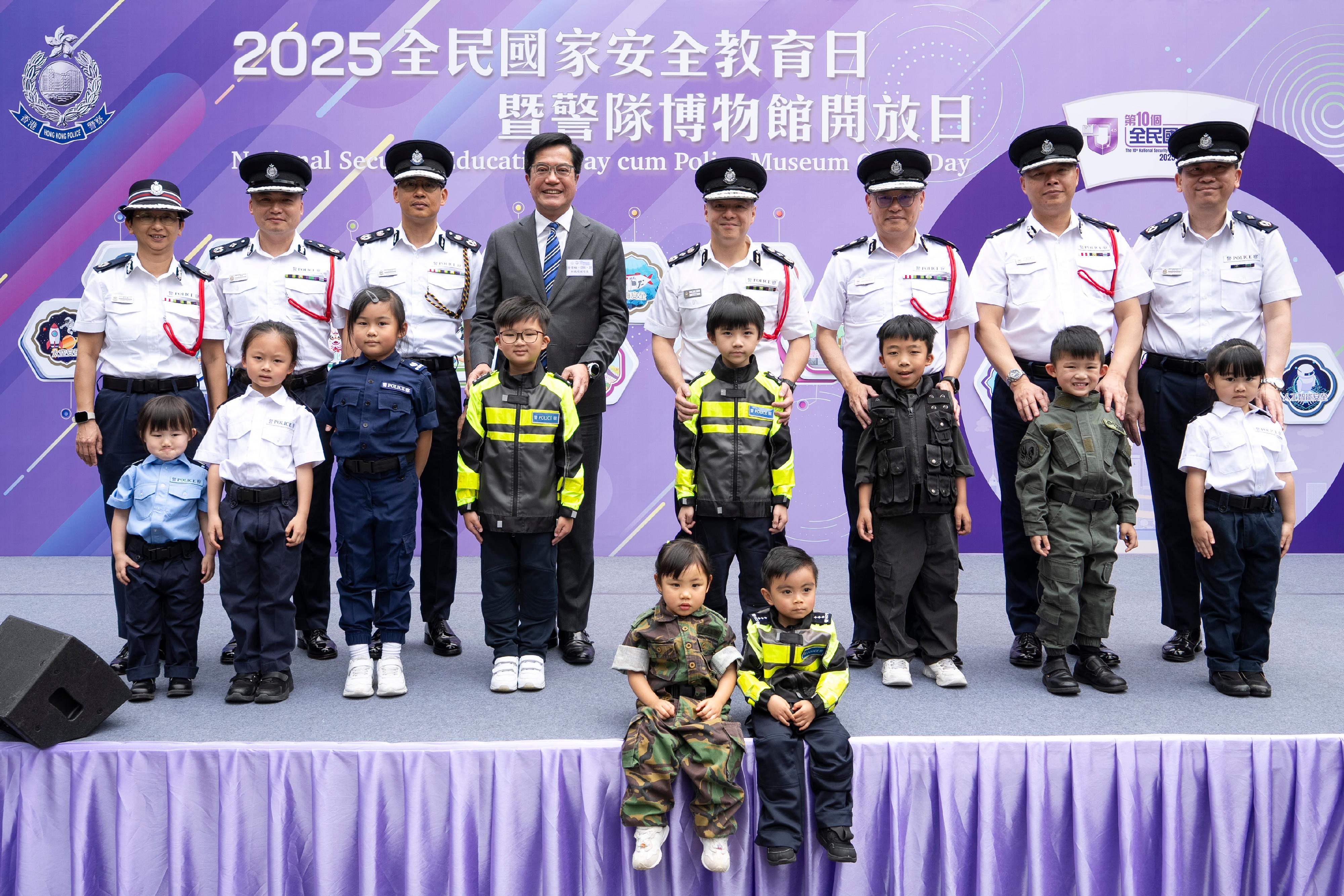 警務處今日（四月十三日）舉辦「全民國家安全教育日暨警隊博物館開放日」。圖示（後排左起）香港警察學院院長陳綺麗、警務處國家安全處處長江學禮、警務處副處長（管理）陳俊燊、財政司副司長黃偉綸、警務處處長周一鳴、警務處副處長（國家安全）簡啟恩、警務處人事及訓練處處長蔡展鵬及香港輔助警察隊總監梁世光，帶領身穿迷你警察制服的小朋友，一同主持開幕禮。