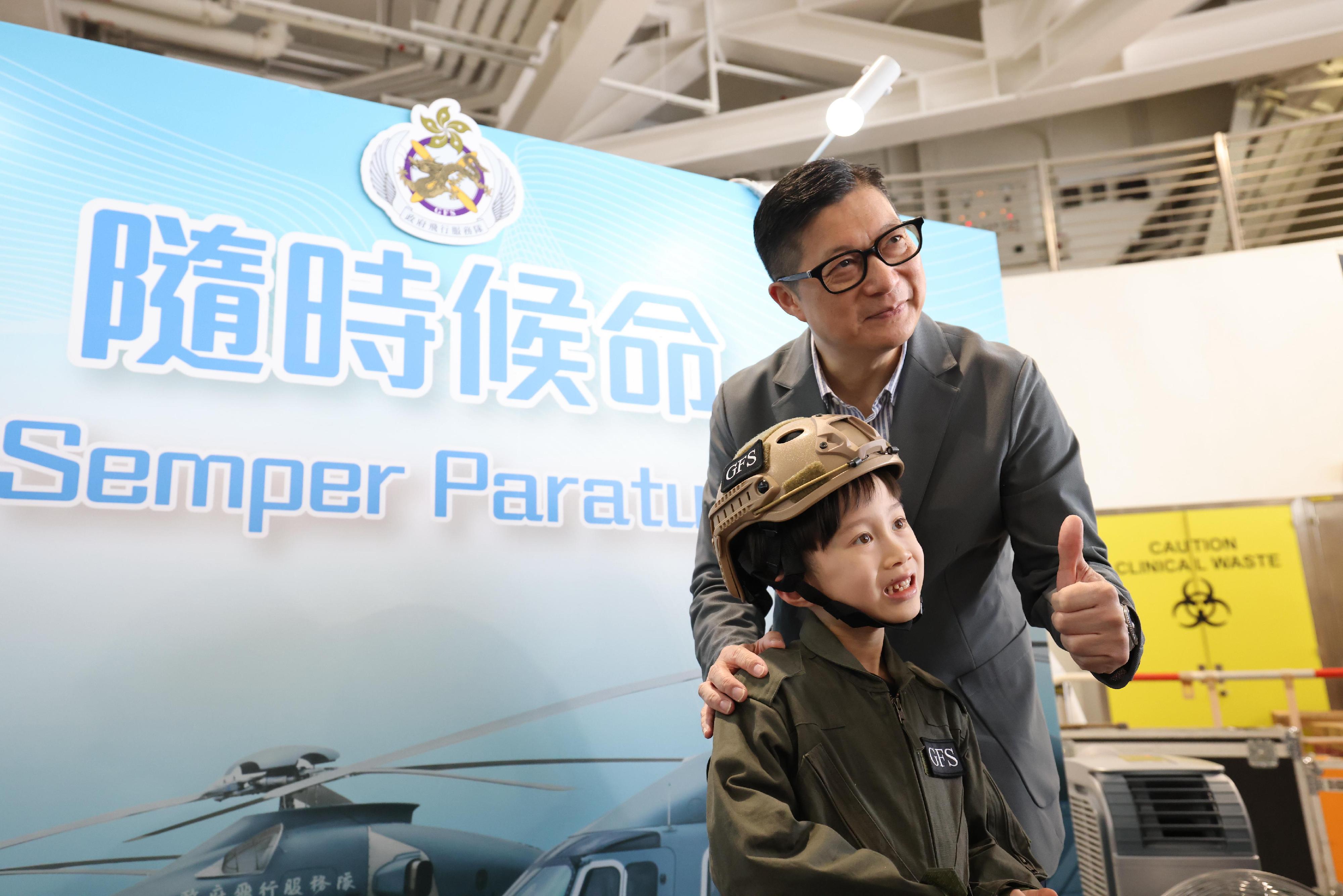 To promote the National Security Education Day, the Government Flying Service (GFS) held an open day today (April 13) at the GFS Kai Tak Division. Photo shows the Secretary for Security, Mr Tang Ping-keung (right), taking a photo with a member of the public visiting the exhibition booth.