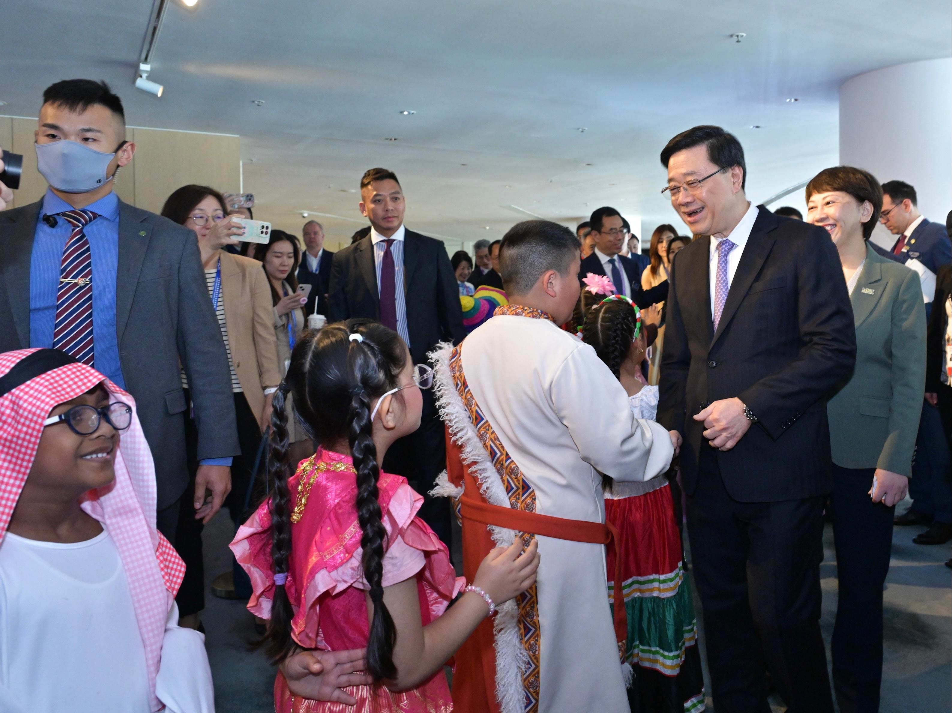 The Chief Executive, Mr John Lee, attended the 2025 World Tourism Cities Federation Hong Kong Fragrant Hills Tourism Summit today (April 15). Photo shows Mr Lee (second right) interacting with children in costumes.