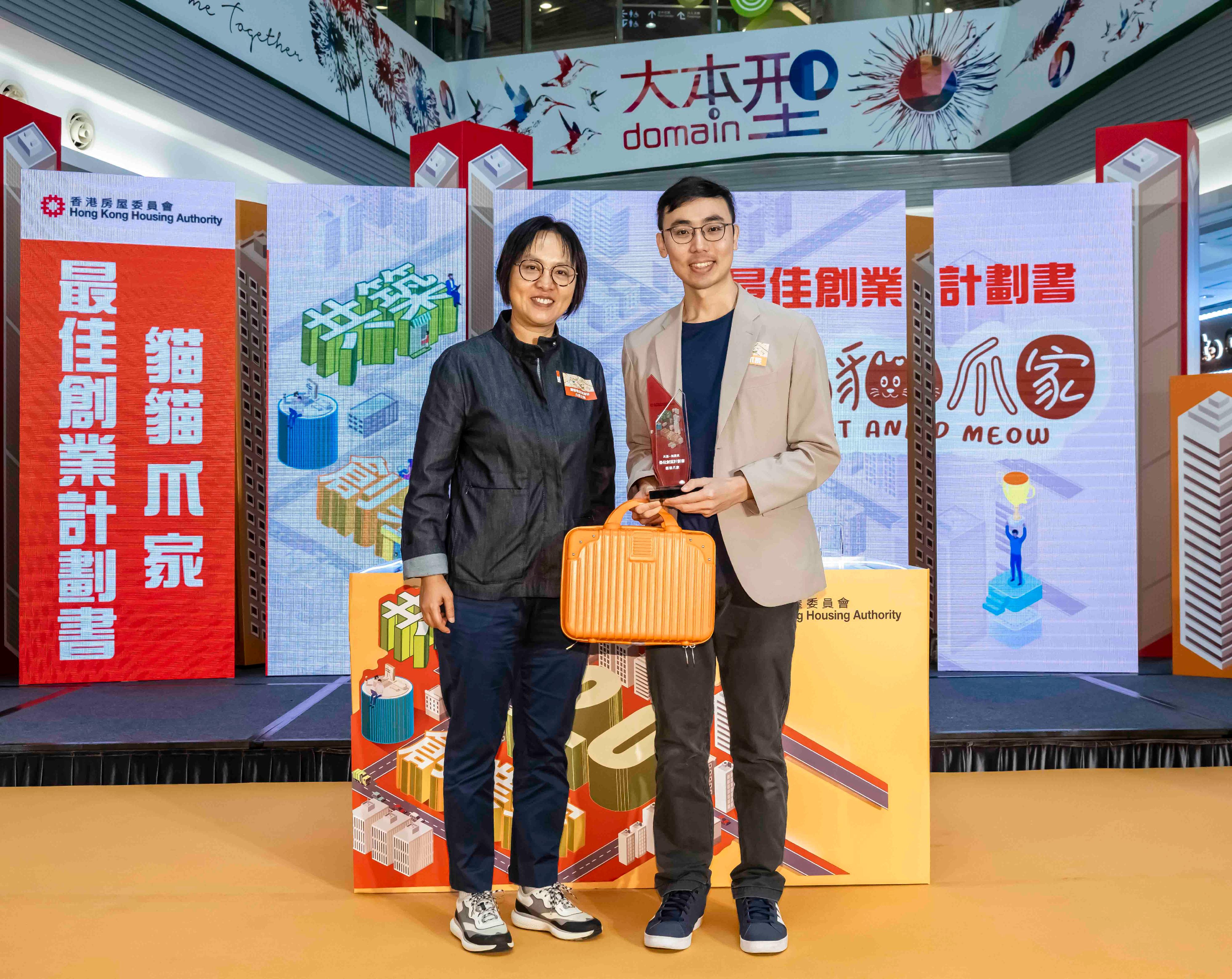 The Hong Kong Housing Authority (HA) announced the Well Being·Start-Up 2.0 Programme today (April 17), joining hands with private shopping centres and commercial partners to continue its support for youth entrepreneurship and inject vitality and innovation into the community. Photo shows the Chairman of the HA's Commercial Properties Committee, Ms Serena Lau (left), presenting the Best Business Plan award to a representative of the winner, Lost and Meow.