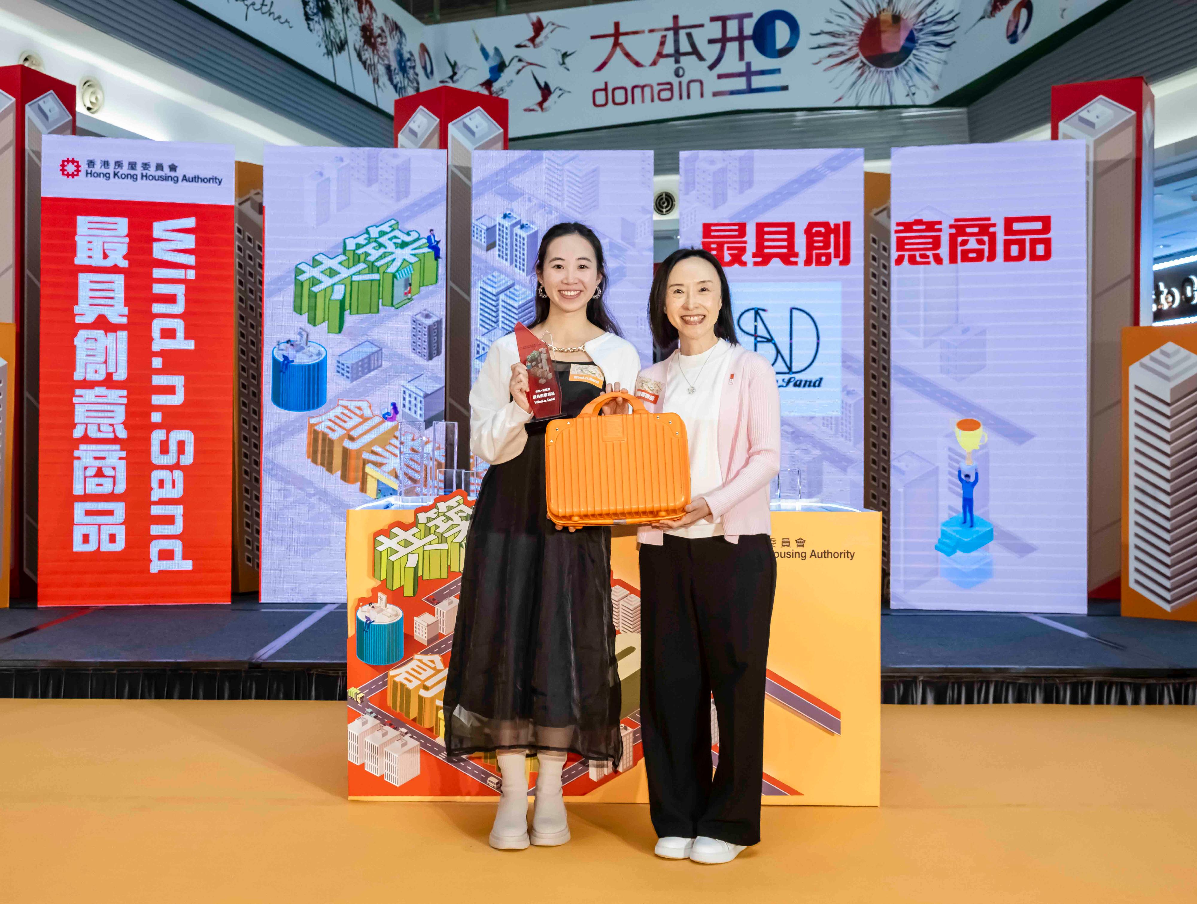 The Hong Kong Housing Authority announced the Well Being·Start-Up 2.0 Programme today (April 17), joining hands with private shopping centres and commercial partners to continue its support for youth entrepreneurship and inject vitality and innovation into the community. Photo shows the Permanent Secretary for Housing and Director of Housing, Miss Charmaine Lee (right), presenting the Most Creative Product award to a representative of the winner, Wind.n.Sand. 