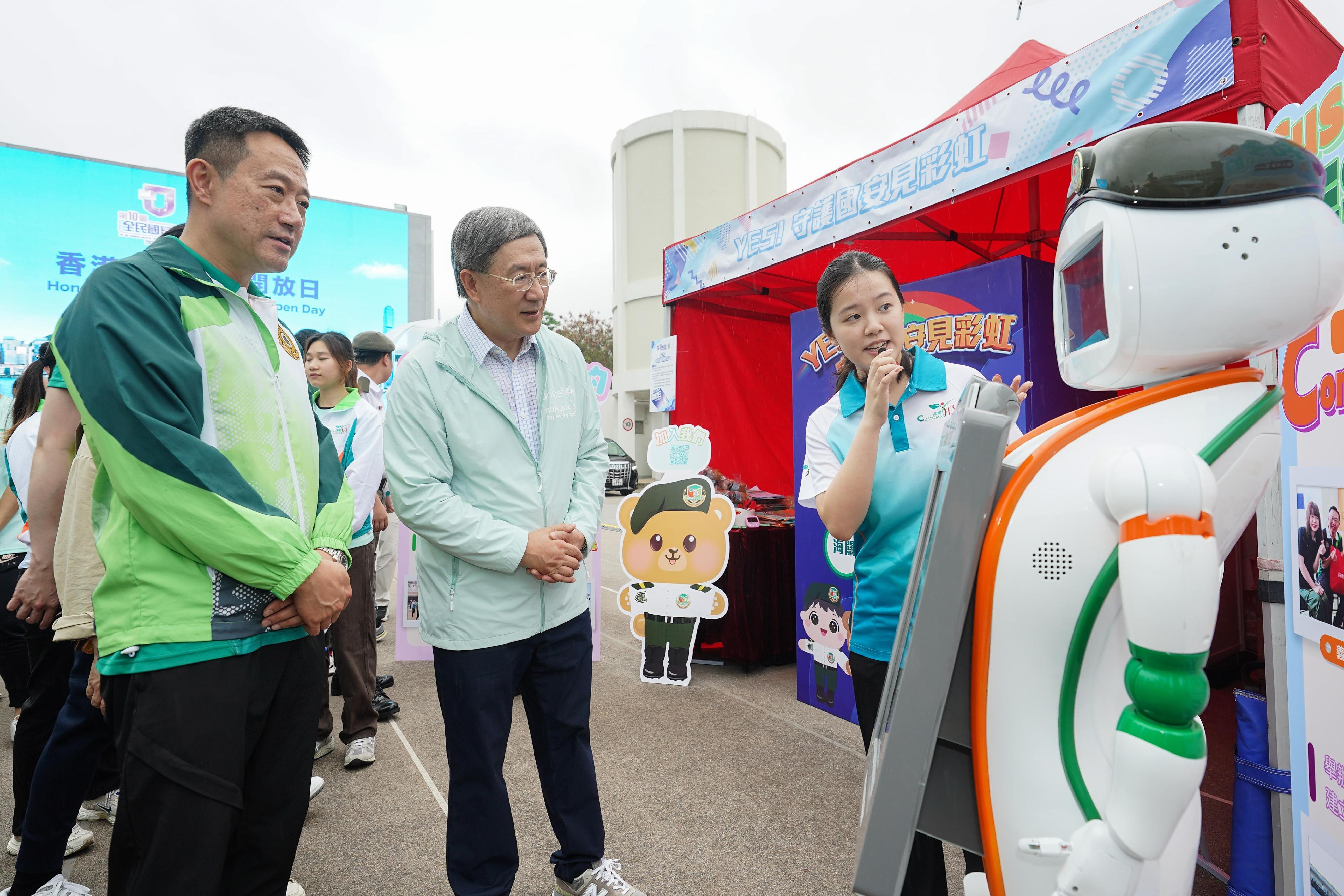 Hong Kong Customs today (April 18) held the Hong Kong Customs College Open Day. Photo shows the Deputy Chief Secretary for Administration, Mr Cheuk Wing-hing (centre), and a "Customs YES" youth member      participating in the national security-themed game booth.