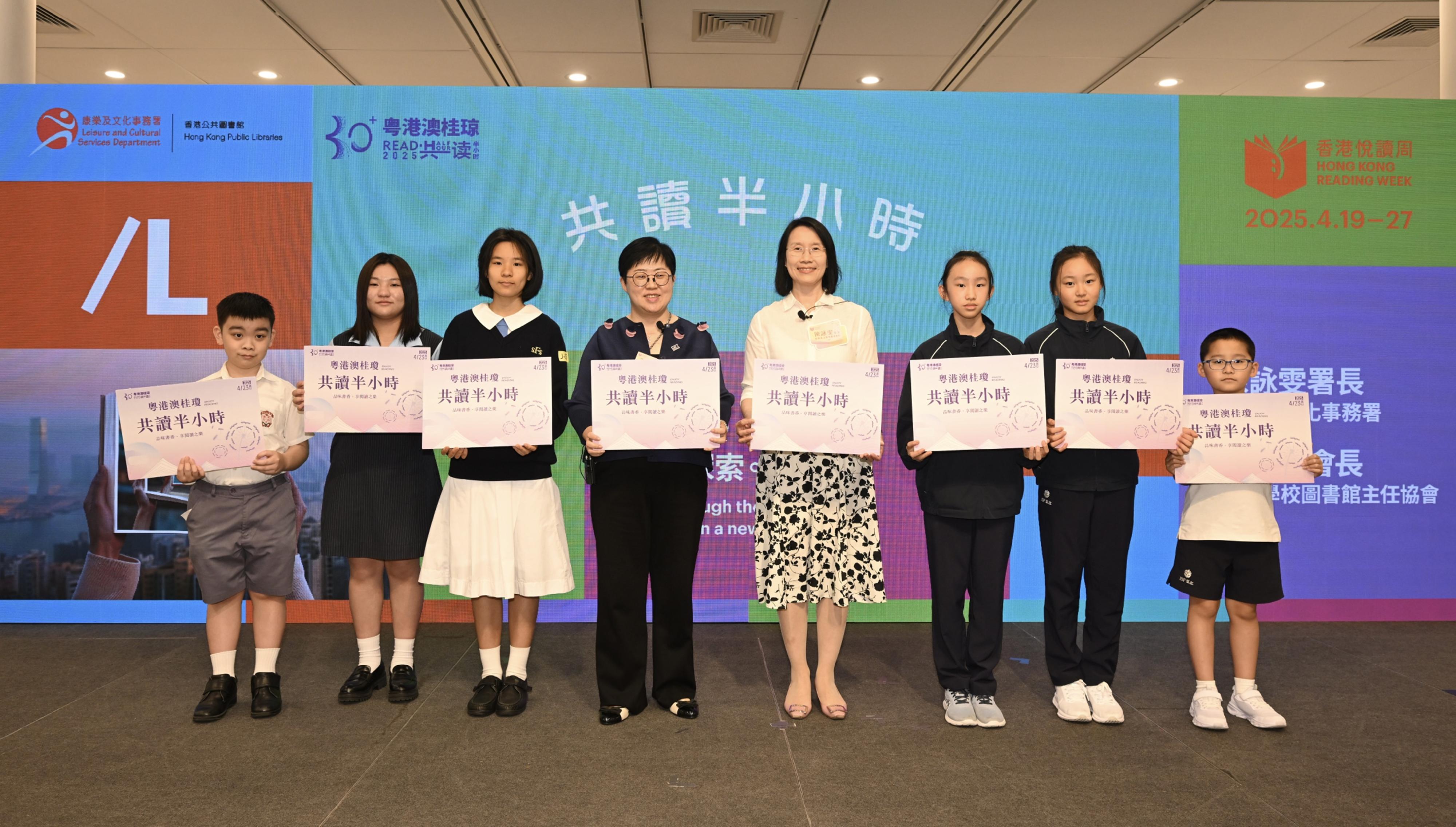 康樂及文化事務署（康文署）轄下香港公共圖書館今日（四月二十三日）與不同持份者合作設立共讀點，舉行共讀半小時活動。康文署署長陳詠雯（右四）出席在香港中央圖書館舉行的共讀半小時活動，並與香港學校圖書館主任協會會長黃毅娟（左四）和參與活動的學生一同朗讀「共讀宣言」。
