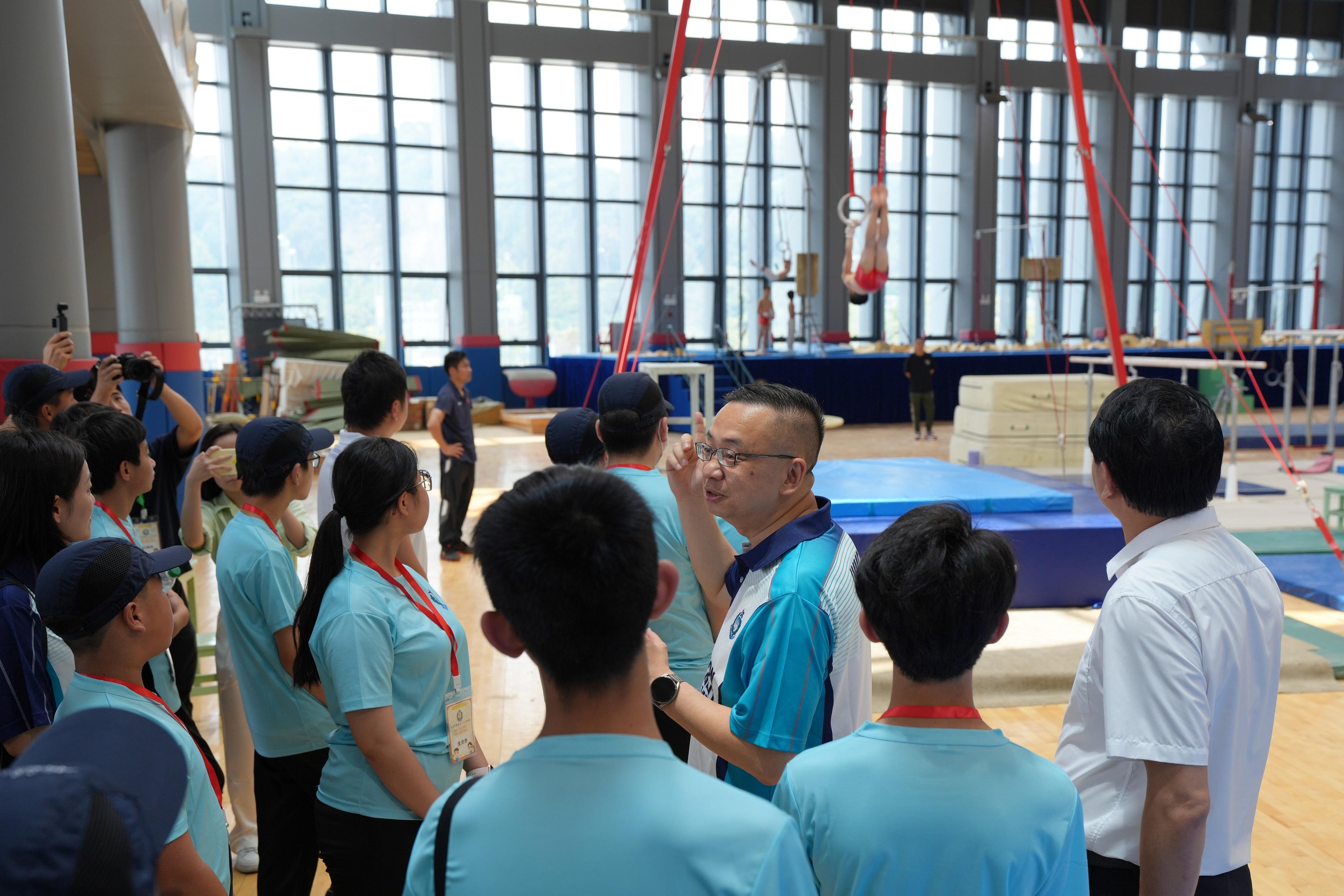 The Immigration Department Youth Leaders Corps (IDYL) organised the three-day National Games in Touch: Chaoshan Exchange Tour from April 22 to 24. Photo shows the Director of Immigration, Mr Benson Kwok, observing daily training of gymnasts with IDYL members at Shantou Sports School.