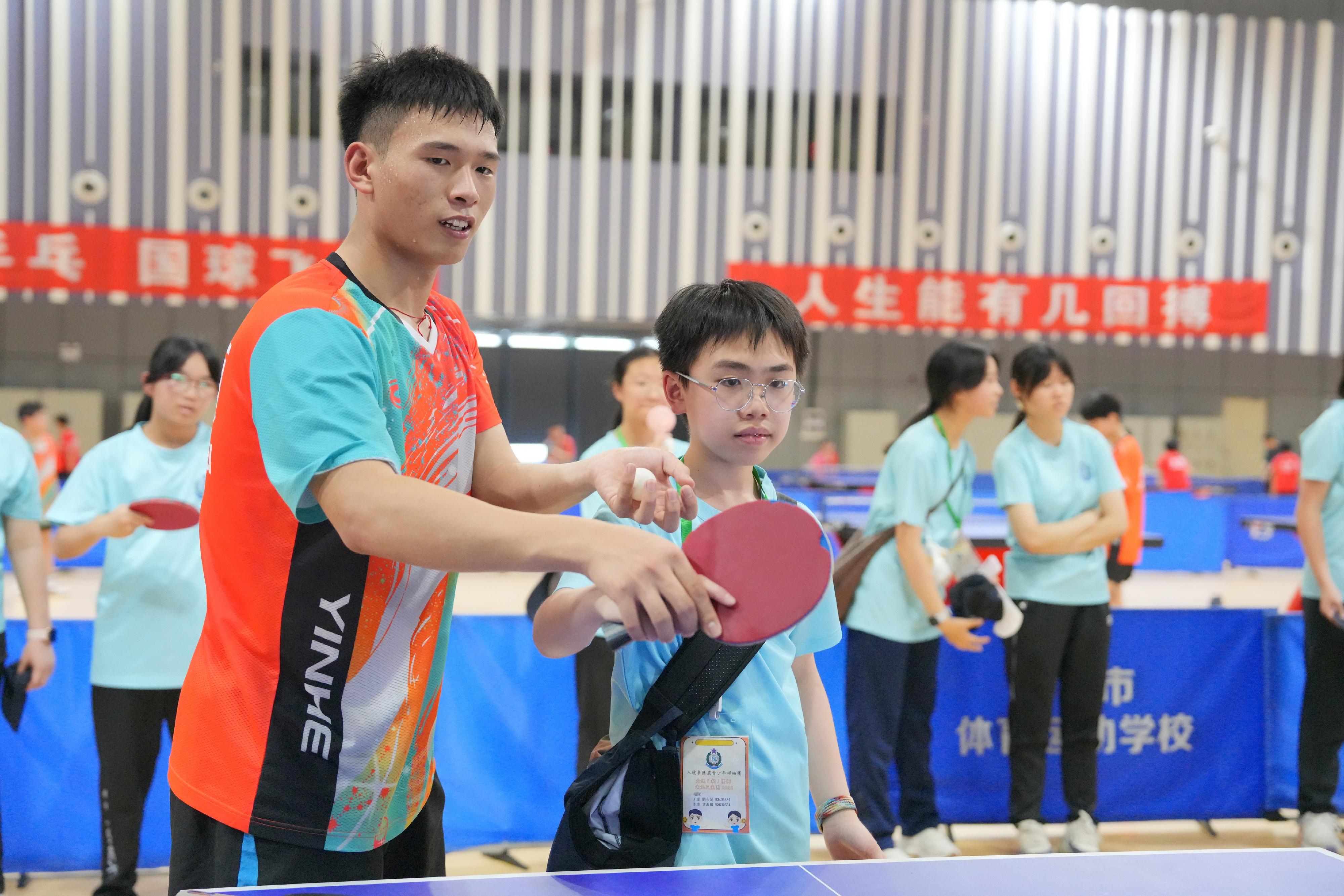 The Immigration Department Youth Leaders Corps (IDYL) organised the three-day National Games in Touch: Chaoshan Exchange Tour from April 22 to 24.  Photo shows a student athlete from Shantou Sports School coaching table tennis techniques with an IDYL member.