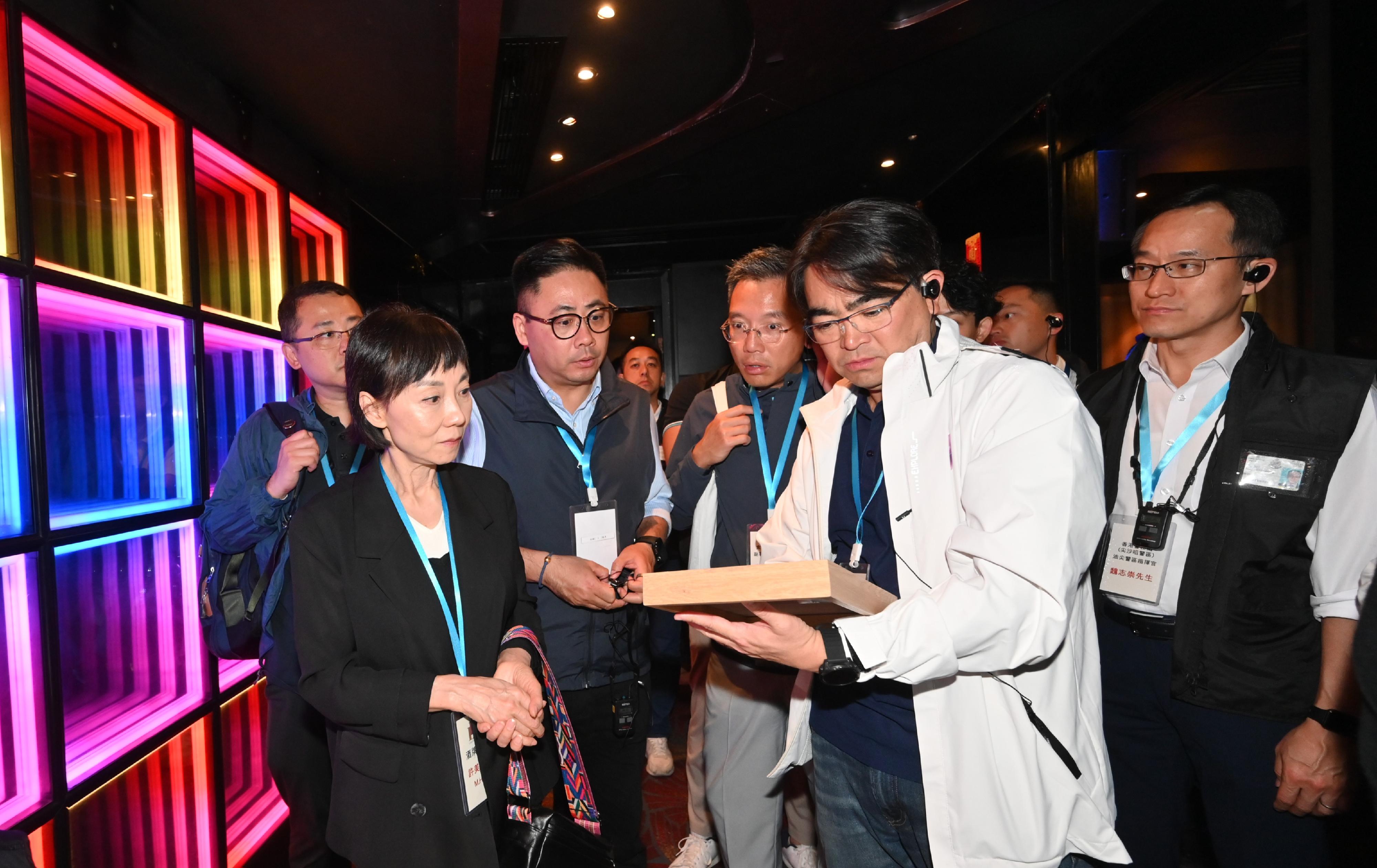 Members of the Liquor Licensing Board, led by the Board Chairman, Ms Hui Mei-sheung, visited a number of premises with liquor licences in Central District and Tsim Sha Tsui District in the early hours today (April 27) to learn more about the operation of the premises and enforcement action by the Police and the Fire Services Department. Photo shows Ms Hui (front row, left); and the Director of Food and Environmental Hygiene, Mr Donald Ng (front row, right), viewing the liquor licence of a premises.