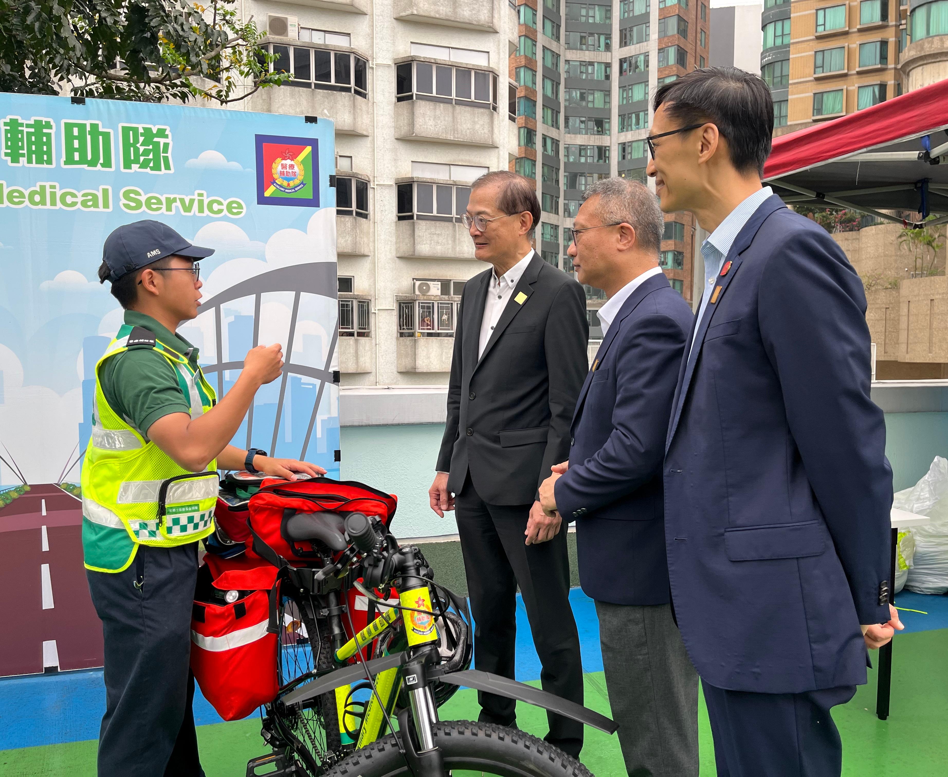 The Auxiliary Medical Service (AMS) held its National Security Education Day cum AMS 75th Anniversary Open Day at its Ho Man Tin Headquarters today (April 27). Photo shows the Chief Staff Officer of the AMS, Mr Wong Ying-keung (second right), introduced the AMS First Aid Bicycle Service to the Secretary for Health, Professor Lo Chung-mau (second left), and the District Officer (Kowloon City), Mr Ivanhoe Chang (first right).