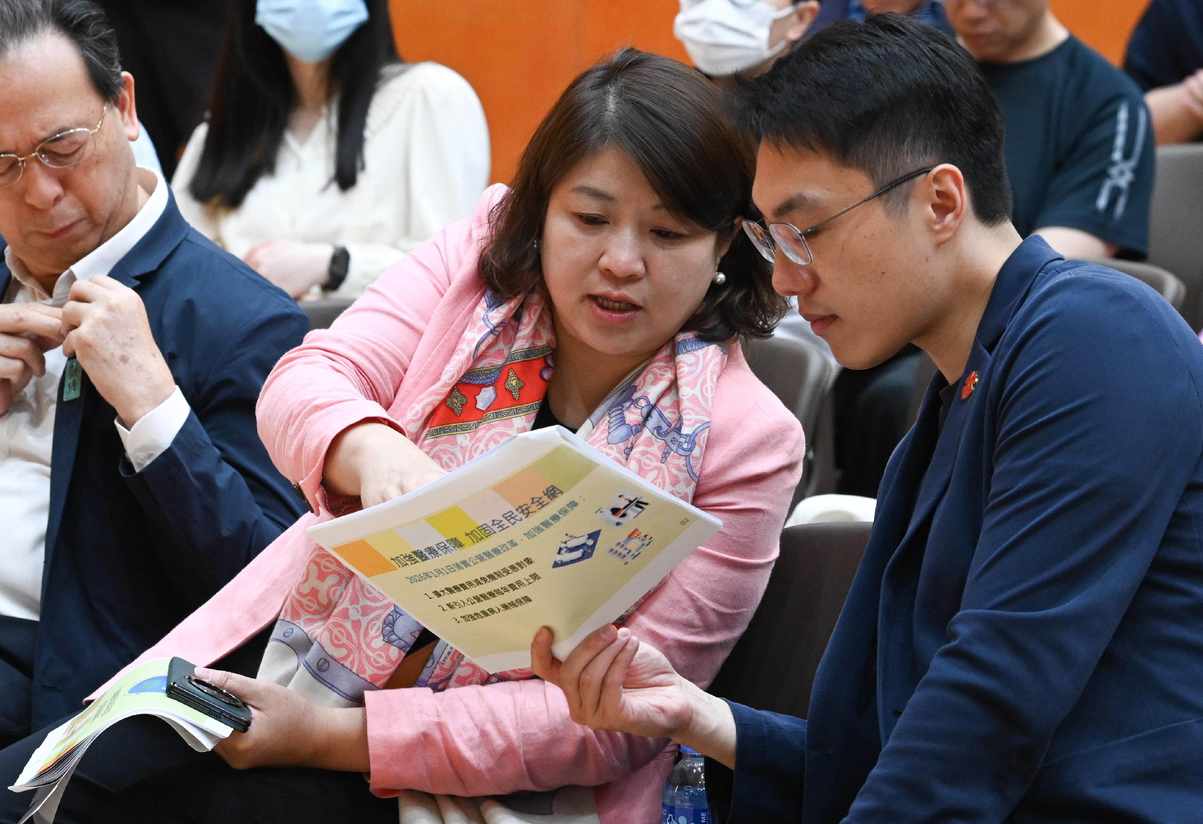 The Under Secretary for Health, Dr Libby Lee (centre) attends the first District Council briefing on fees and charges reform for public healthcare to explain the details of the reform to an attendee today (April 29).
