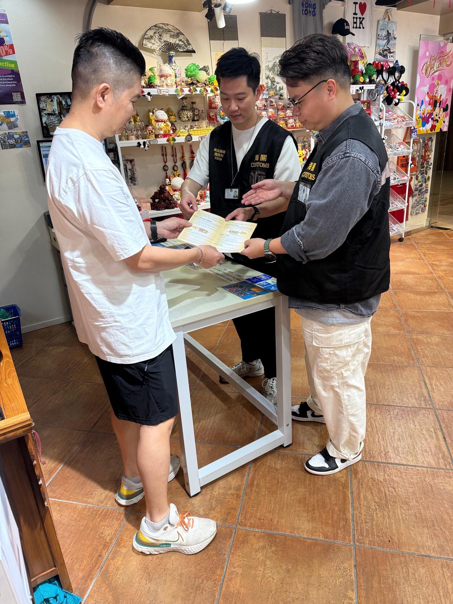 香港海關四月二十四日起展開特別行動，於內地勞動節黃金周期間加強巡查全港各區購物熱點，提醒商戶遵守《商品說明條例》（《條例》）規定，以保障及推廣本地消費者和旅客的權益。圖示海關人員在尖沙咀向商戶進行合規宣傳教育，提醒商戶遵守《條例》的規定。
