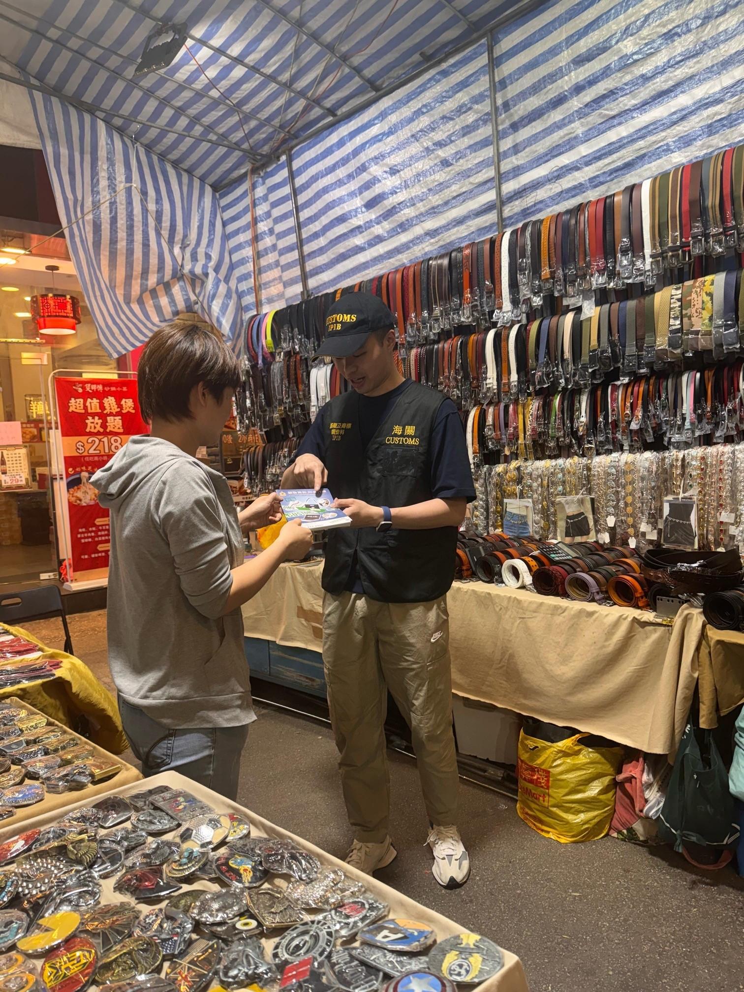 香港海關四月二十四日起展開特別行動，於內地勞動節黃金周期間加強巡查全港各區購物熱點，提醒商戶遵守《商品說明條例》（《條例》）規定，以保障及推廣本地消費者和旅客的權益。圖示海關人員在旺角通菜街向小販攤檔派發宣傳單張，並提醒商戶遵守《條例》的規定。